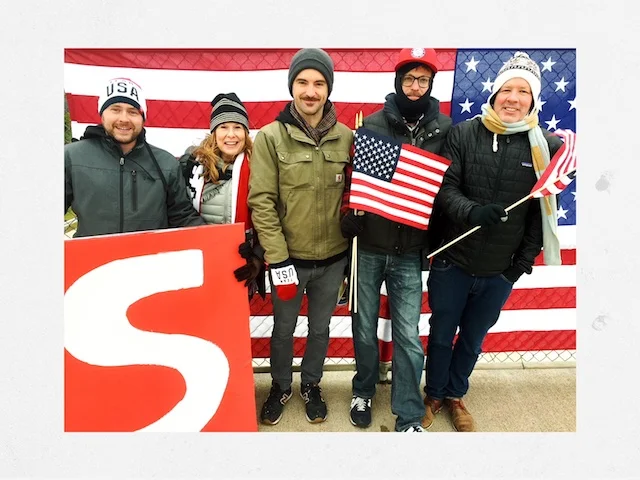 Art Dept with set dresser Bryan Bredahl, decorator Terri Gold, lead man Brian Simpson, dresser Tom Kristjanson and production designer Billy Bostock pose with flags on the I-94 overpass.