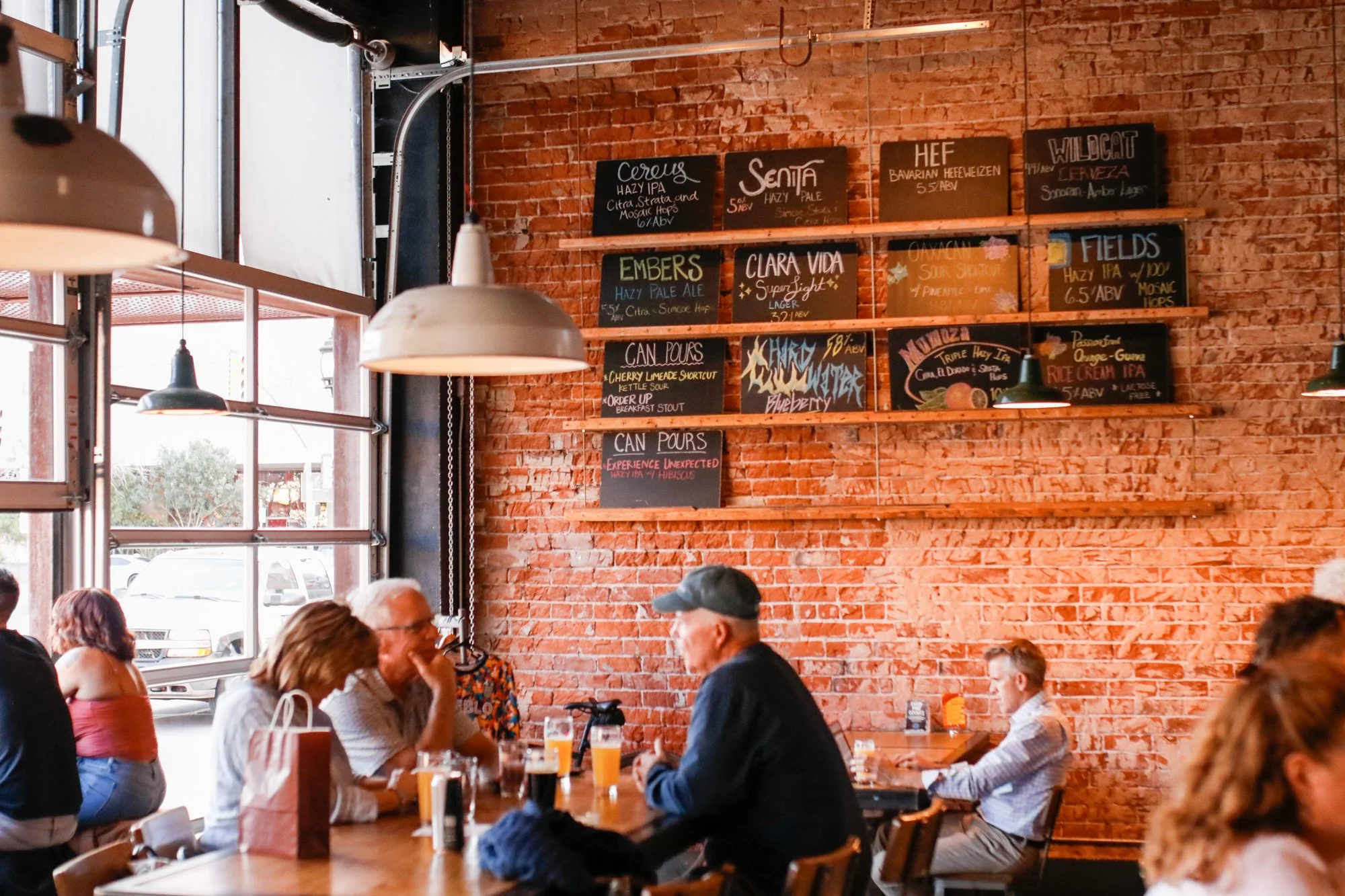 Original Pueblo Vida taproom at 115 E Broadway featuring patrons enjoying a beer on a sunny Tucson afternoon circa 2025.