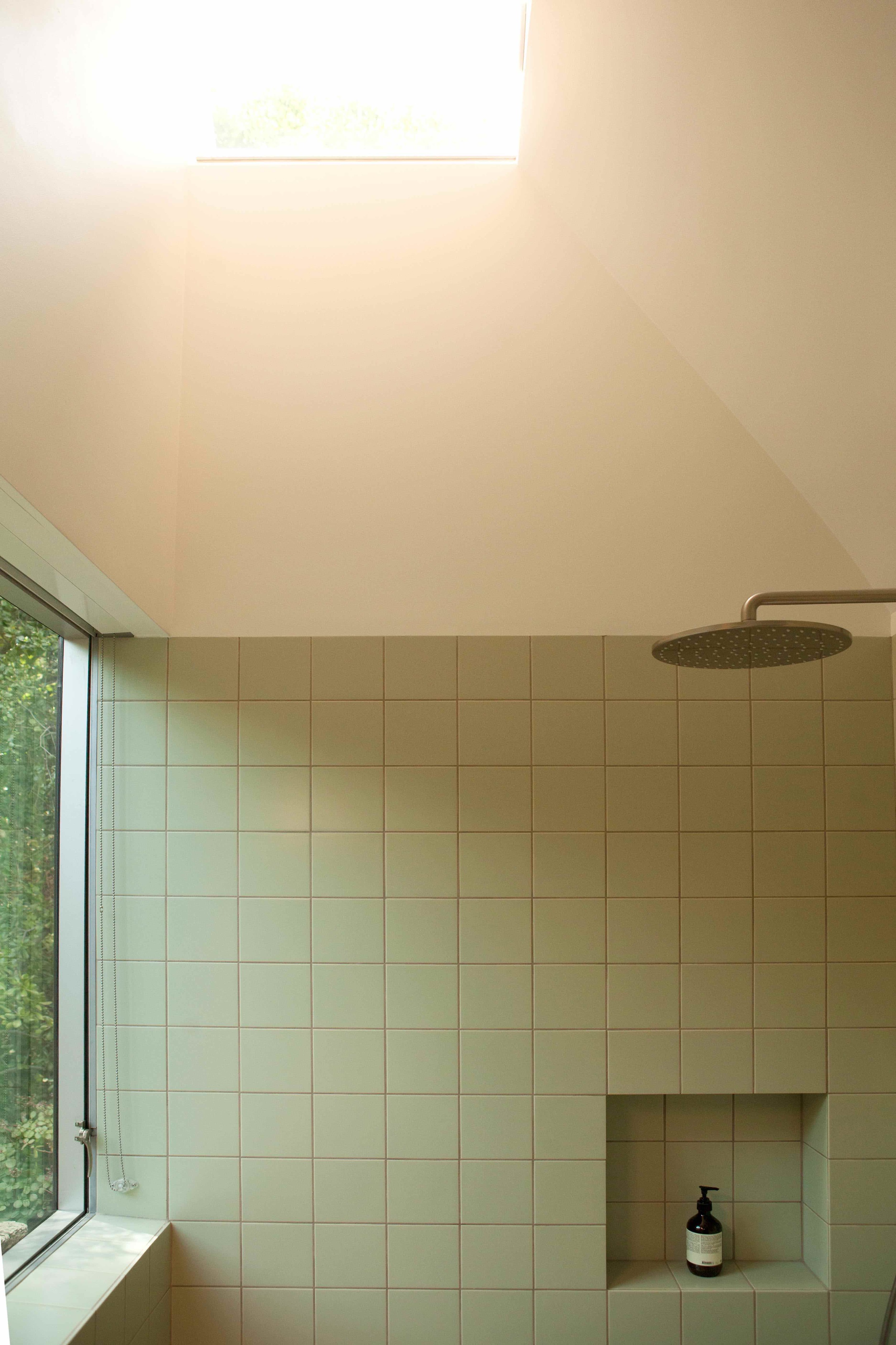  Simple clean Mosa tile in an earthy green shade wraps the lower half of the room. 