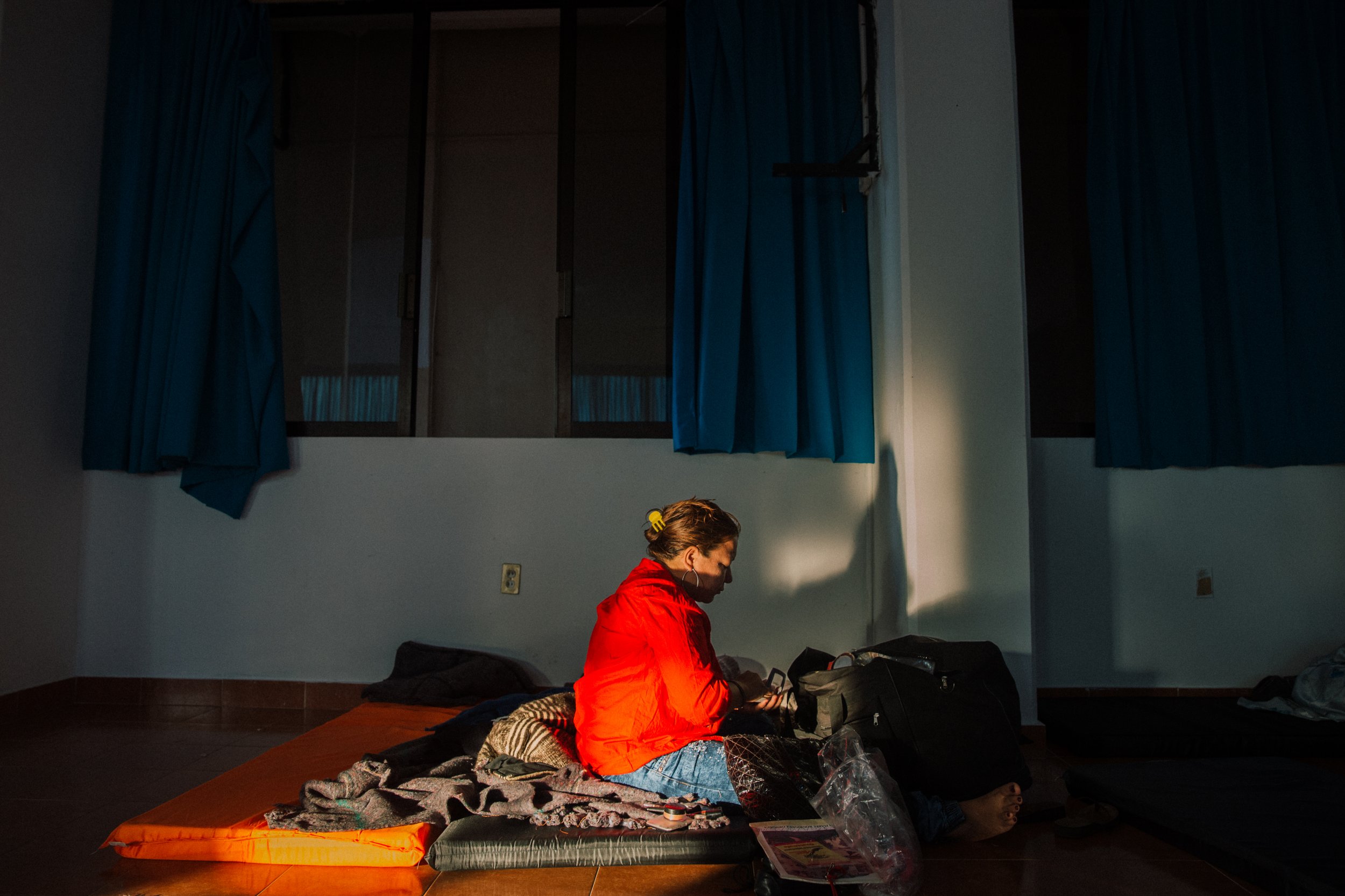  Oneyda Isabel Rodríguez gets ready for the day while sitting on a floor mat in one of the shelters that host the caravan of mothers in Coatzacoalcos, Veracruz, Mexico. Due to limited resources, many of these shelters can only offer basic amenities s