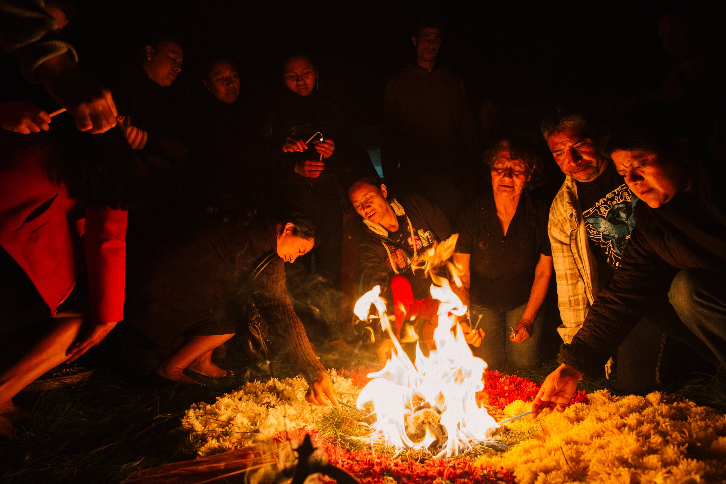  During an ancient Mayan Fire Ceremony held at a migrant shelter in Comitan, Chiapas, Mexico, community members and mothers of the caravan placed offerings in the flame to honor the four grandfathers, Kan, Tzi', Ajmaq, and Ajpu'. The mothers call upo