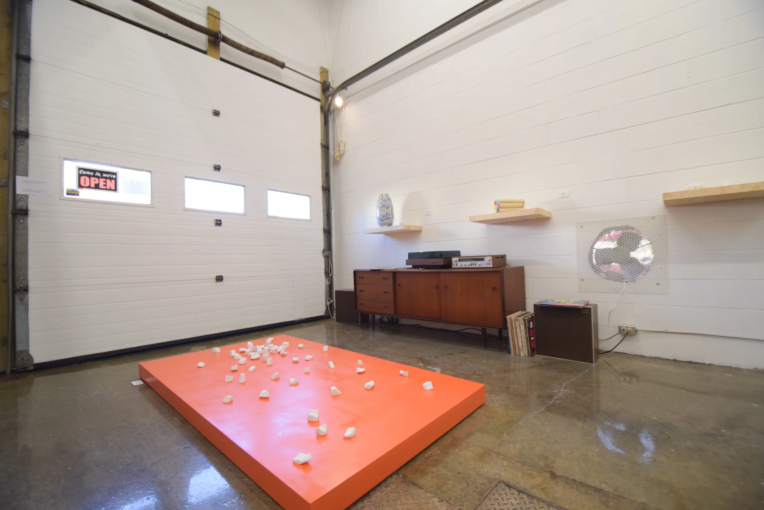 Meredith Snider, One Butternut Squash Chopped, 53 Carved plaster sculptures on a wooden platform painted with 'safety orange' high gloss enamel paint, 2012
