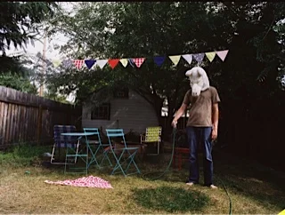 Wolf Man Watering a Patch of Grass After Birthday Party