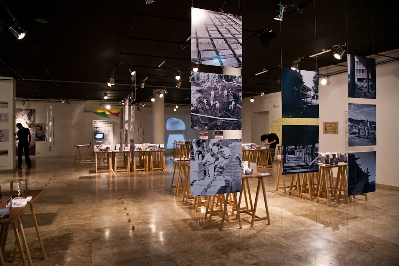 Painéis verticais exibem fotos da construção do prédio da Escola de Arquitetura da UFMG | à esquerda, exposição dos trabalhos vencedores do Concurso Cultural EA 80 anos