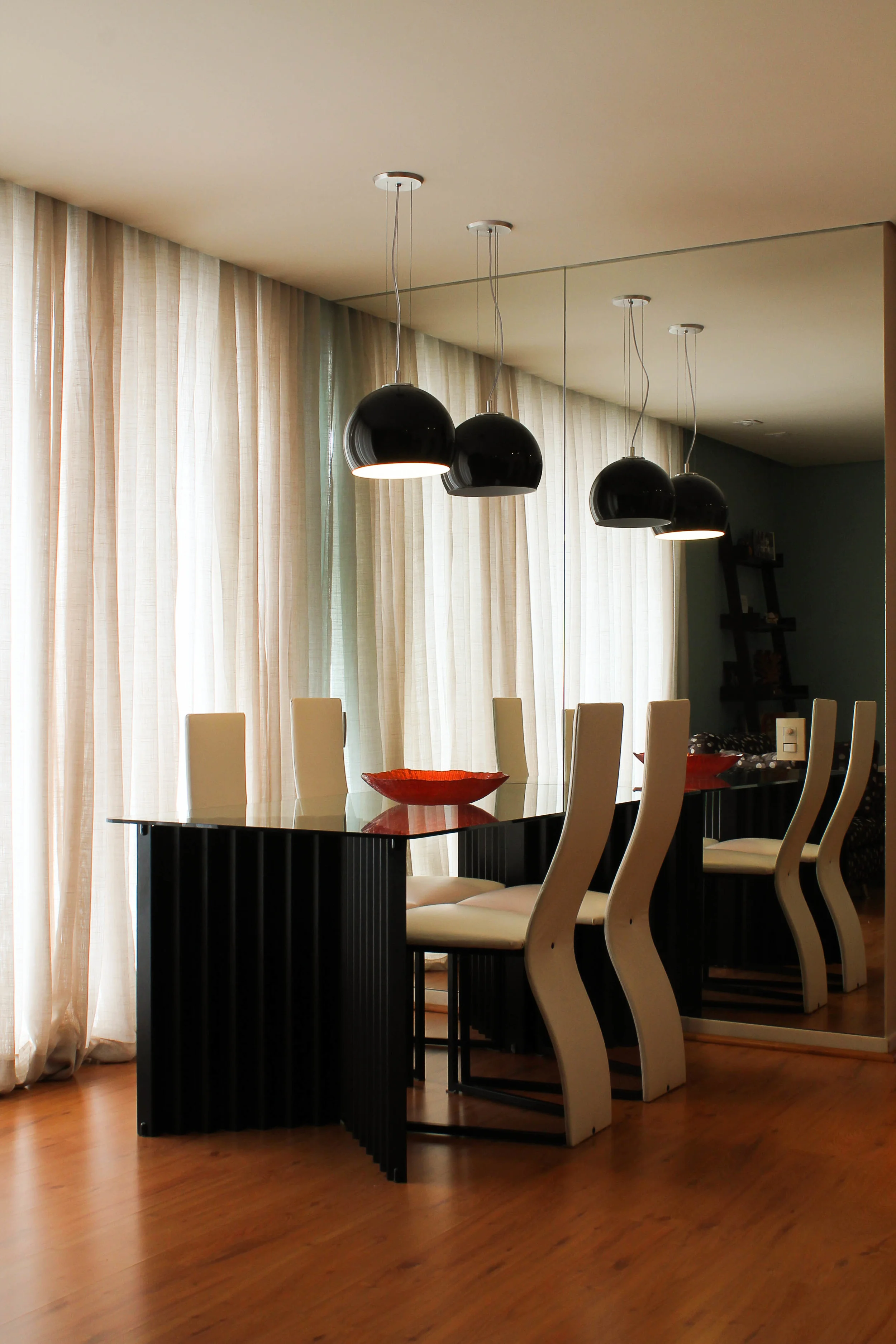 Sala de jantar iluminada por pendentes.