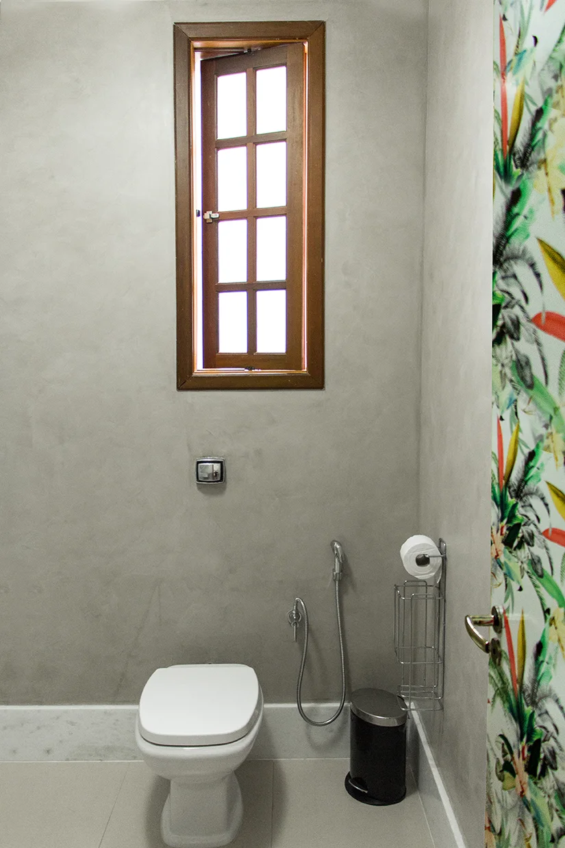 Pintura com textura de concreto nas paredes, rodapé alto de mármore, estampa adesivada na porta.