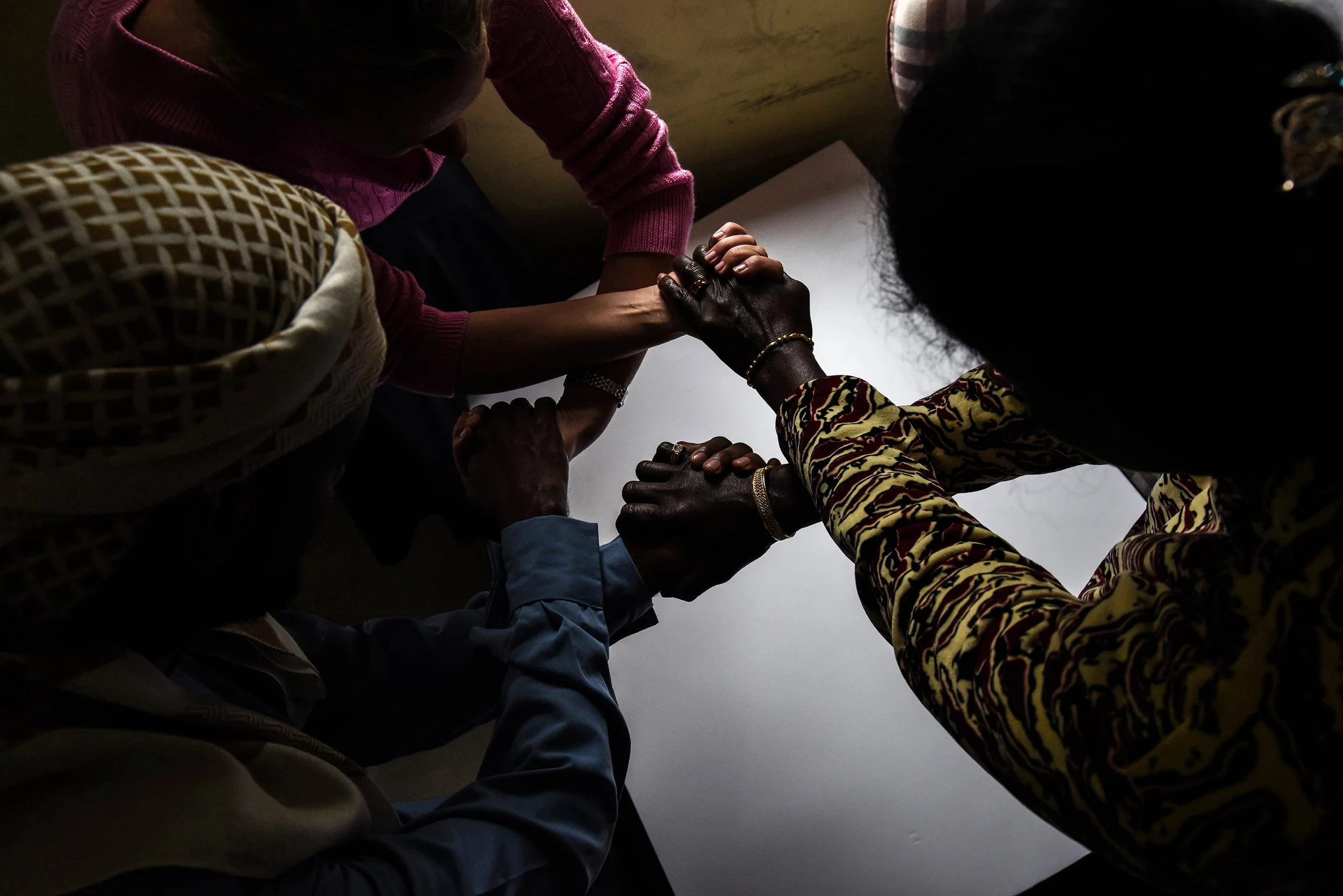 A group of people holding hands together in a circle.