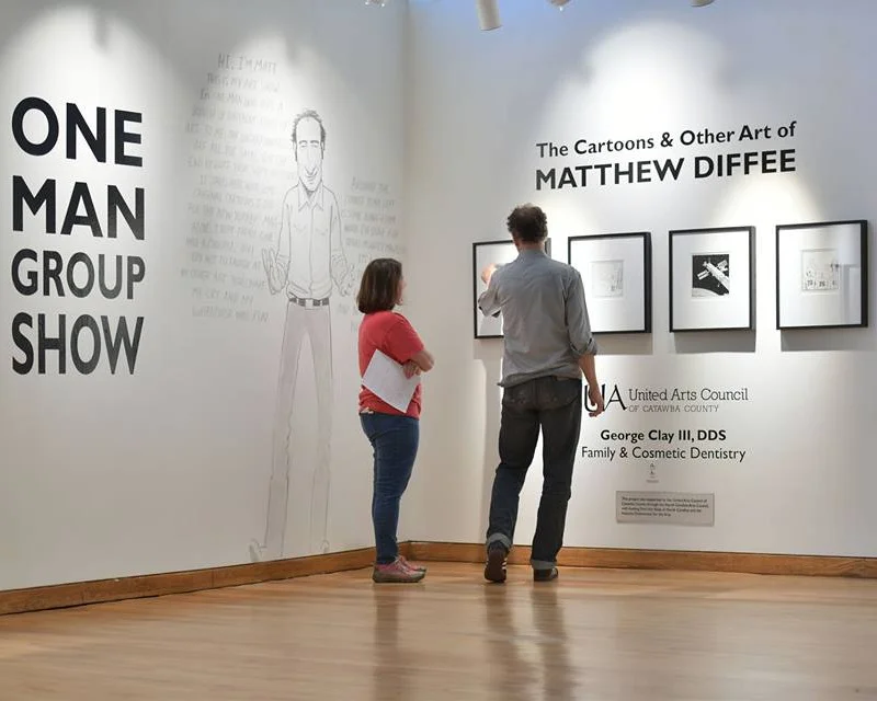 Kristina and Matt Diffee, cartoon artist for The New Yorker, finalize his exhibition. Photo © Jason Overby.