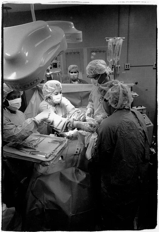 Dr. Judi Binderman hands the 1st of Darlene Miller's twins to an intern.