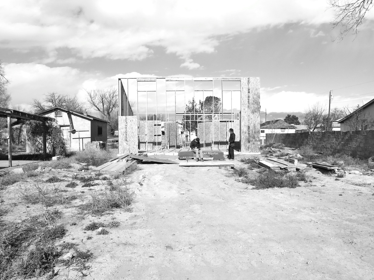 26 December 2014: Making measurements for sheathing. Both east and west sides and most of the north wall are sheathed as high was we can reach. All of the nails are driven in by hand.