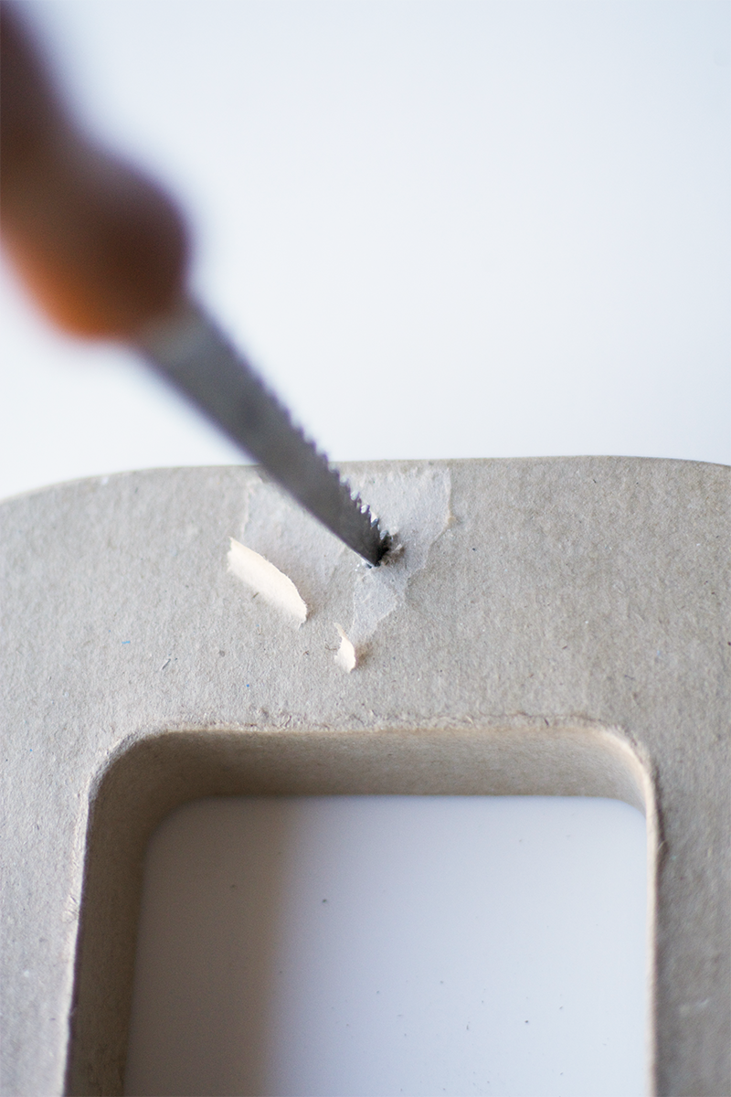 Poke a hole for a nail in the top backside of the lettter.