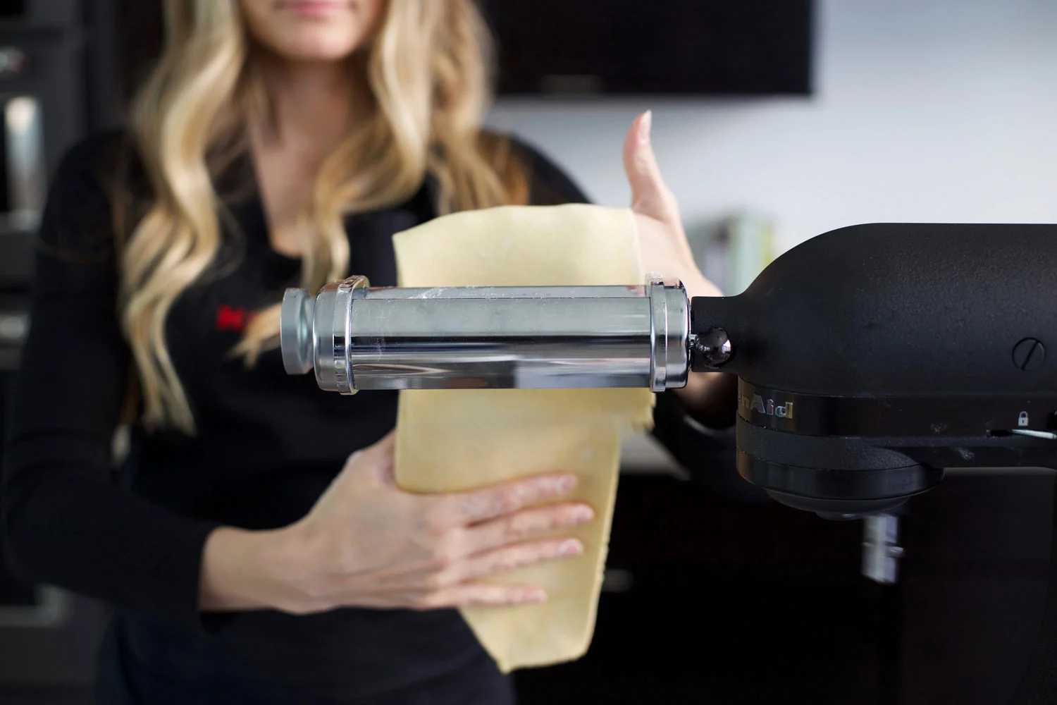 rolling out pasta dough in a machine