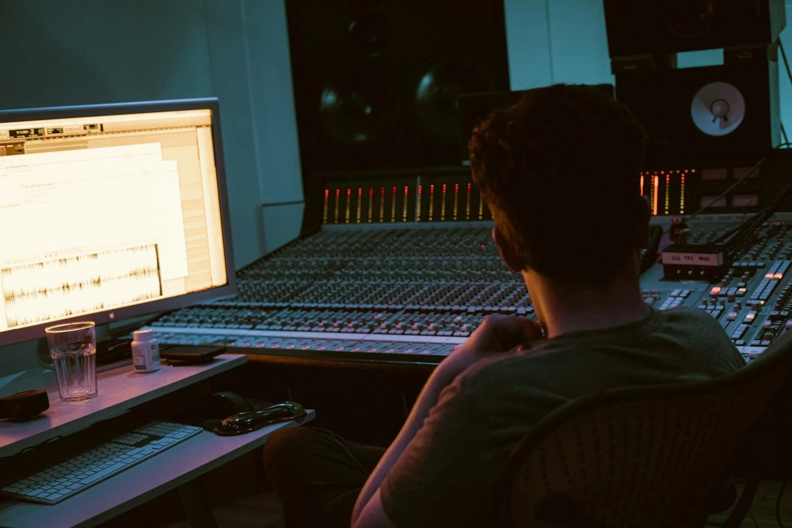 Shane Shanahan is in Westpoint studios, looking at a computer screen displaying audio waveform data, surrounded by sound equipment and other tech gear.