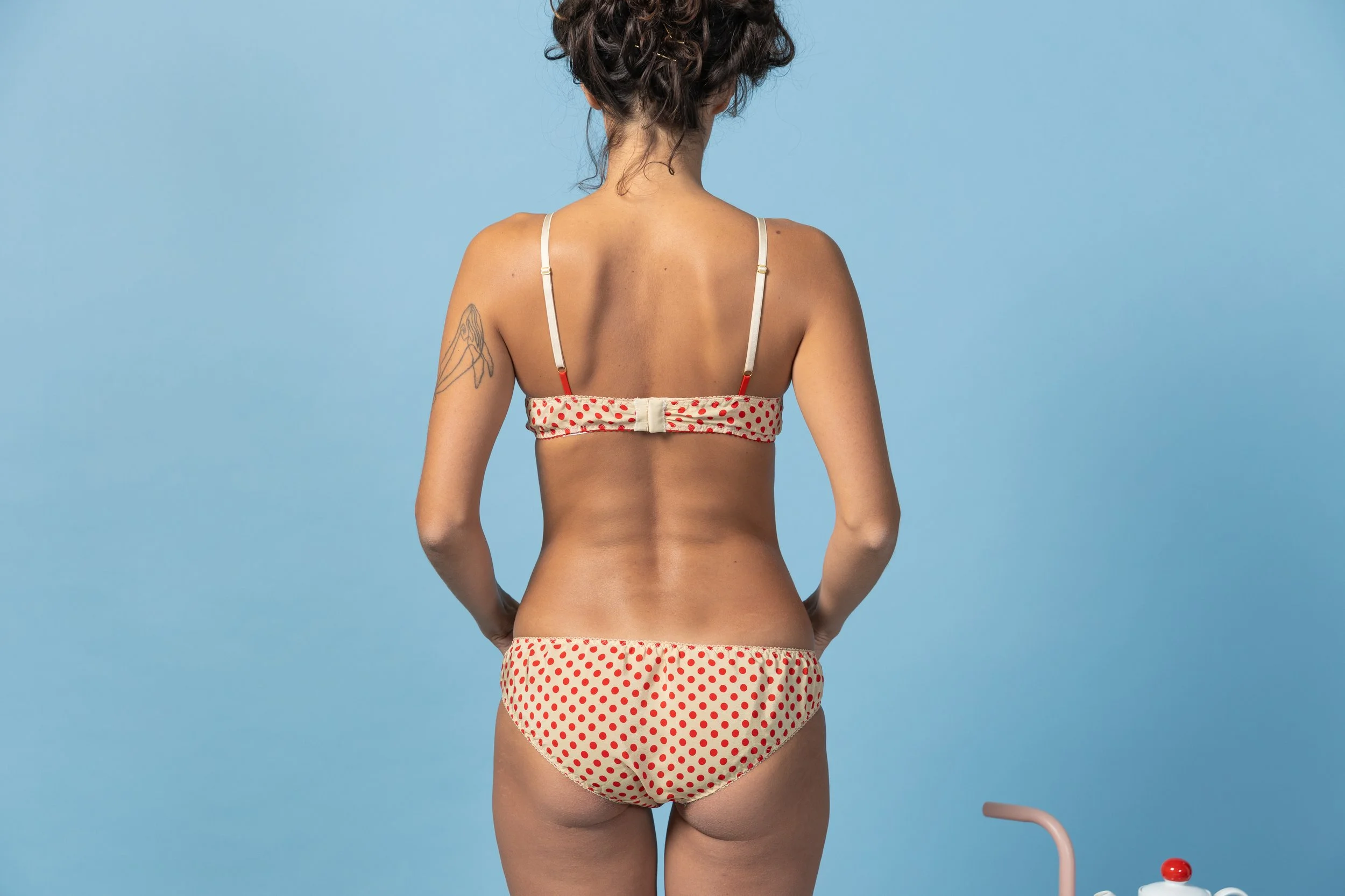 Detailed view of the sophisticated red strap attachment on the back of the silk bralette.
