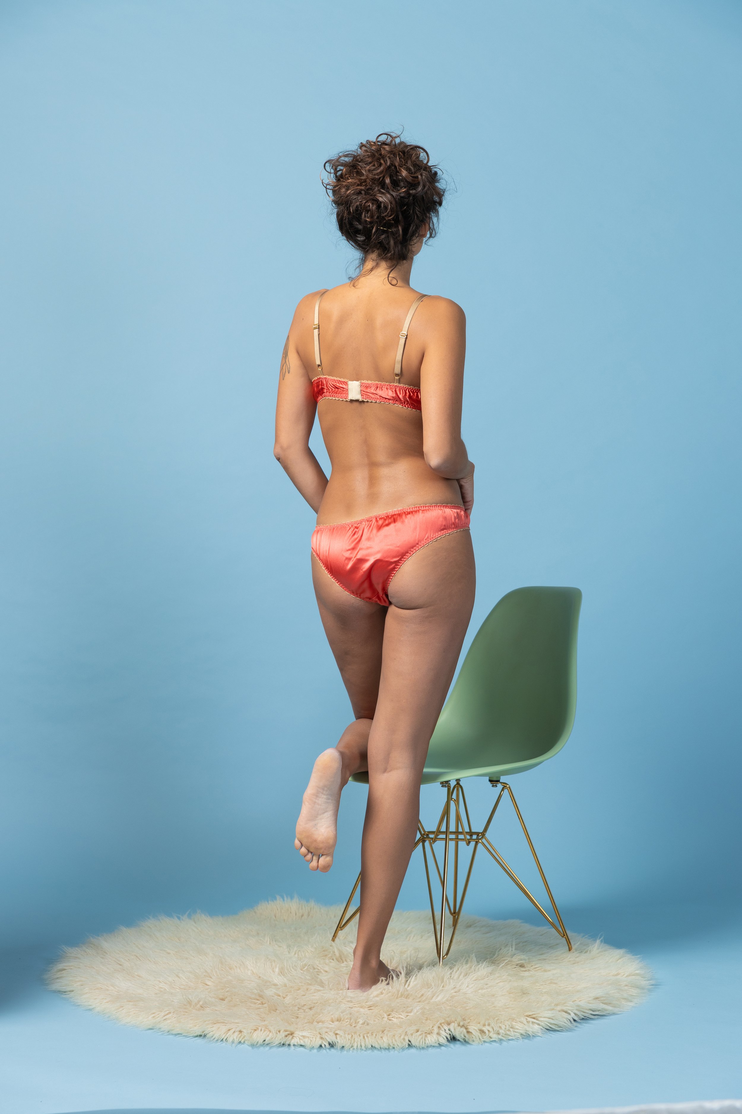 back view of Retro-inspired coral red silk satin lingerie set with champagne-gold trimmings on a model - Voilà le Vélo