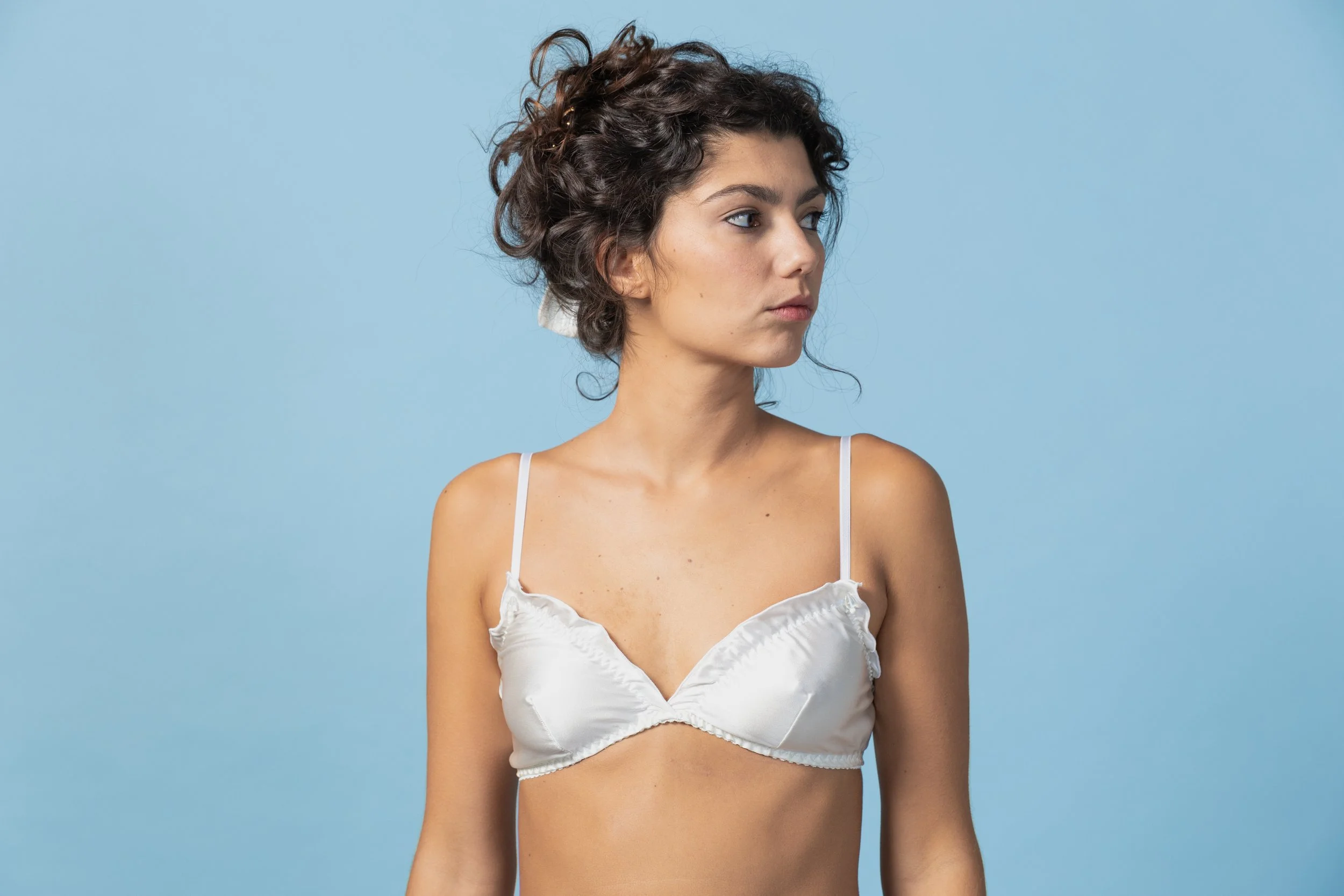 Close-up of Aura silk bridal bralette showing the delicate handmade ruffle detail and gold-plated adjusters.