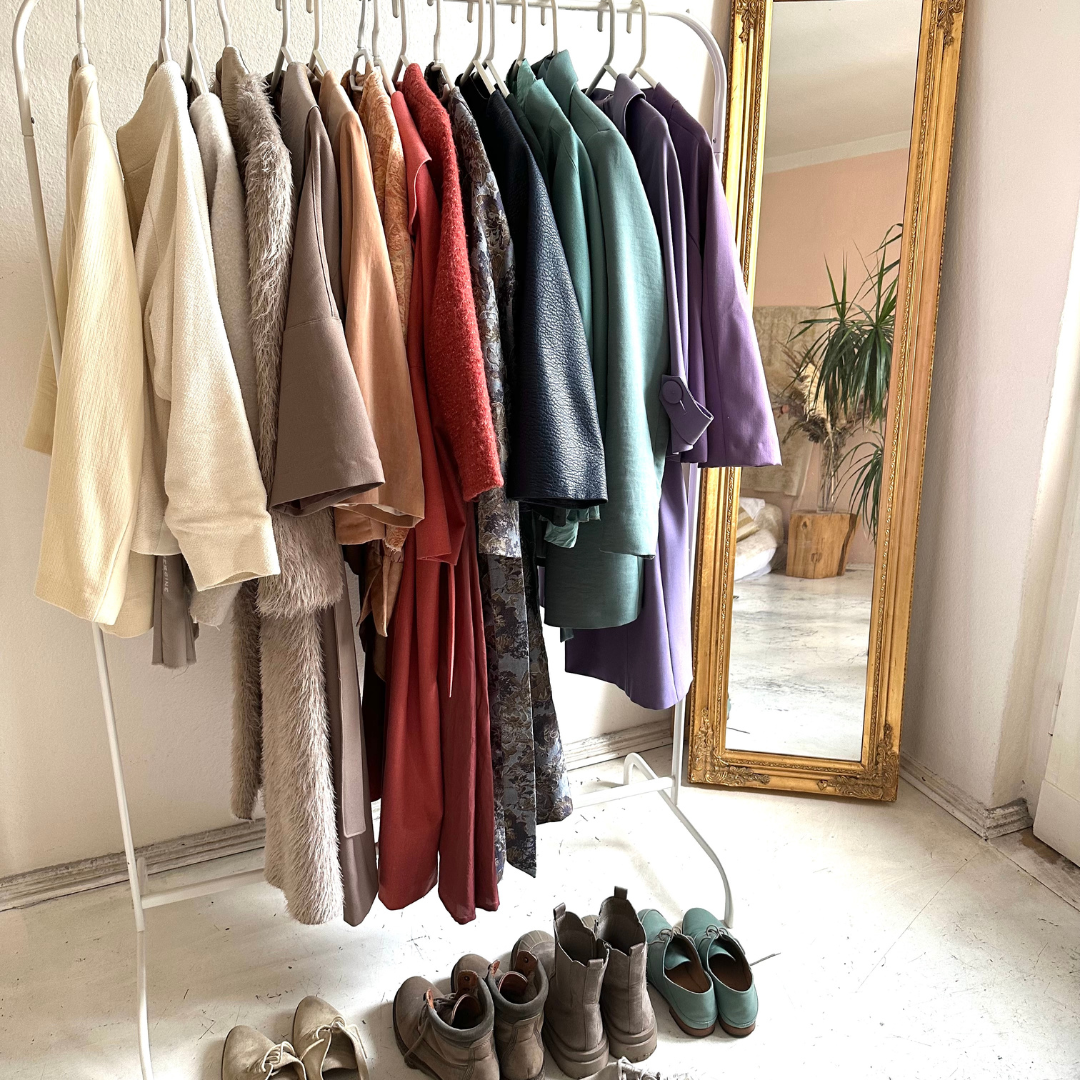 Small versatile wardrobe organized by color, showing a cohesive and intentional clothing system