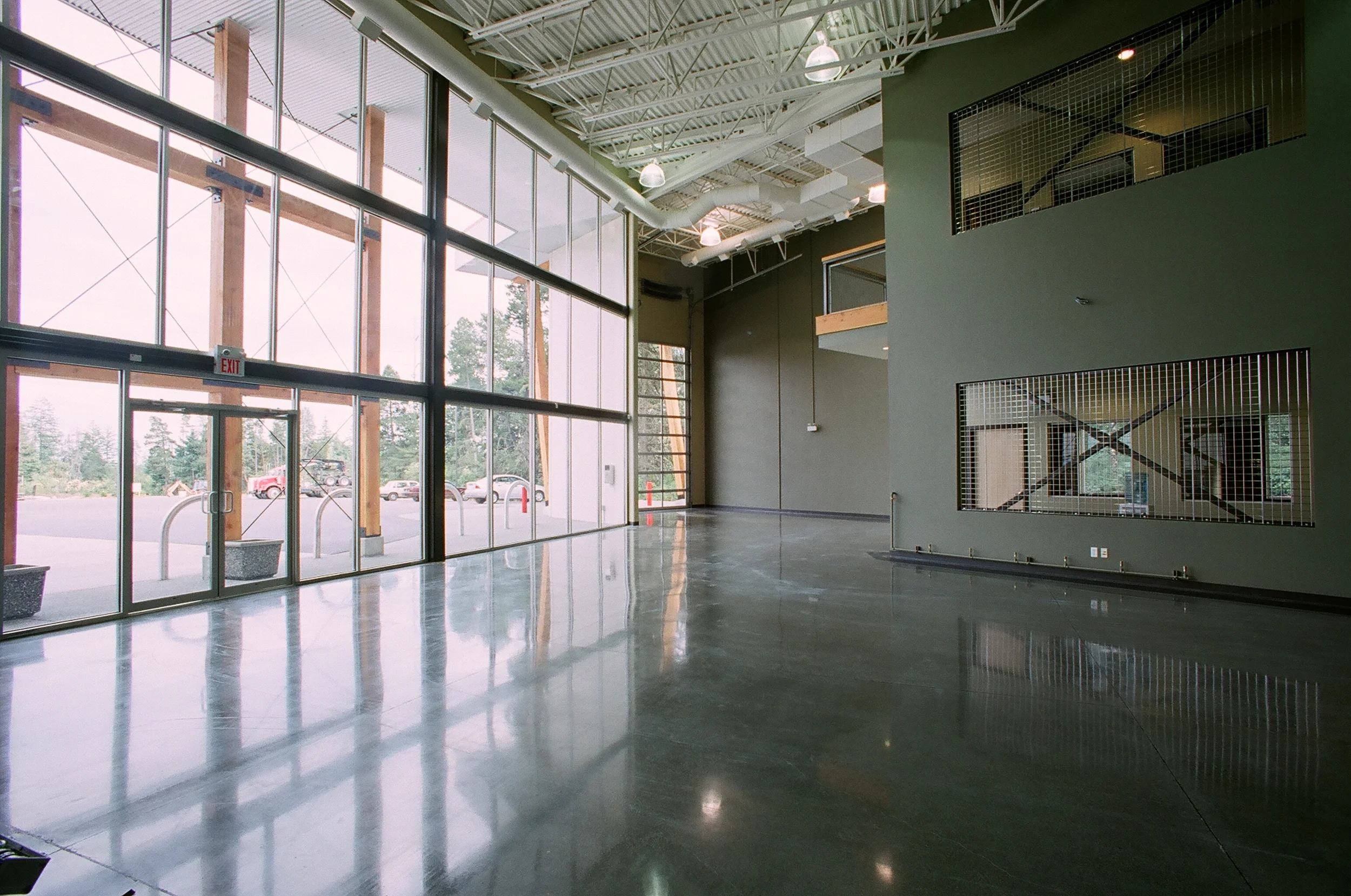  Polished concrete floors and exposed steel roof framing in retail reception area. &nbsp;Interior steel shear wall provides display space and views from perimeter offices into common area. 