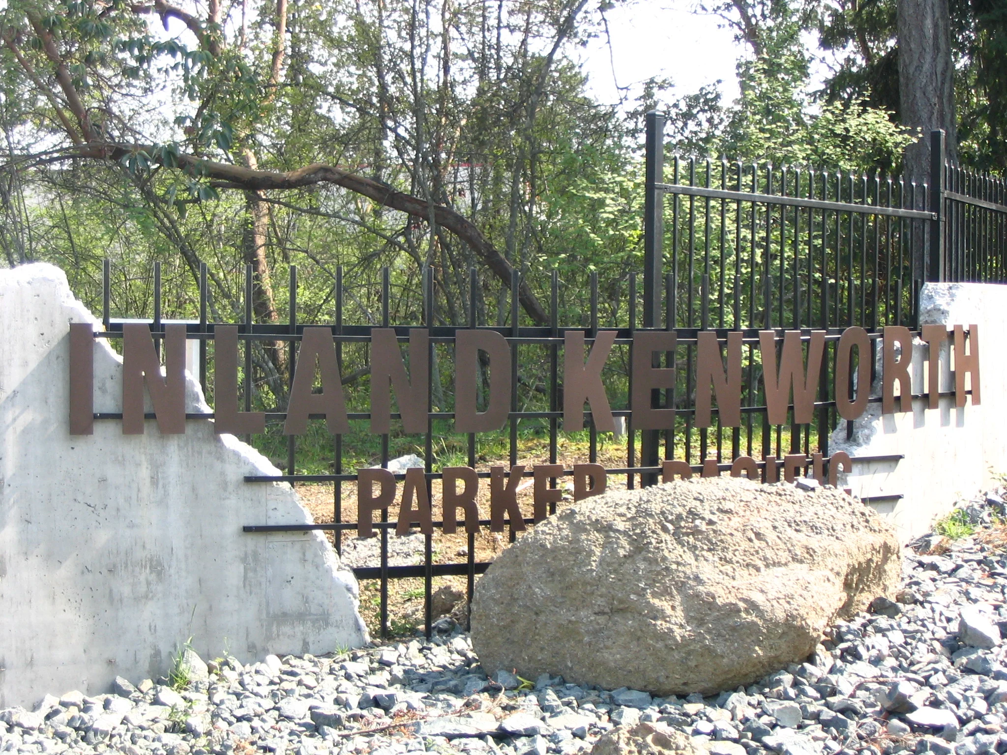  Steel security fencing and signage blended in with new rustic concrete walls at vehicle entry reminiscent of earlier industrial structures on site. 