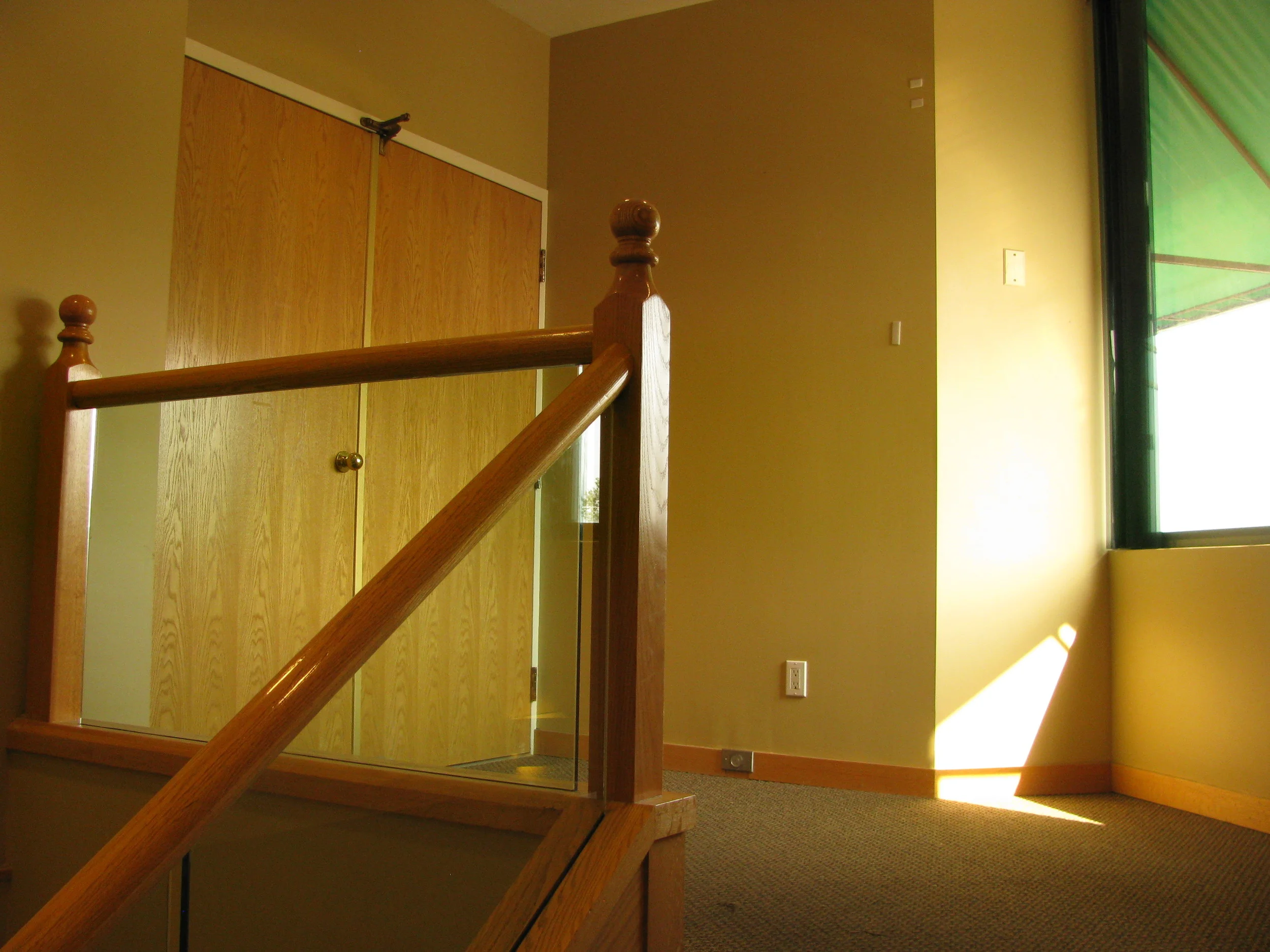  Existing main entry stairway with carpet,&nbsp;oak railings, and doorway to corridor. &nbsp;No floor opening at upper landing. 