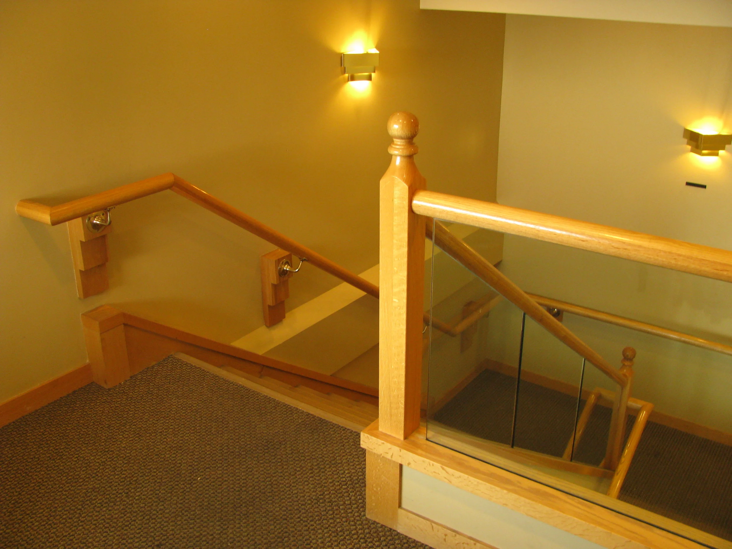  Existing main entry stairway with dropped ceiling and backend of cantilevered exterior canopy beam projecting from&nbsp;wall. 