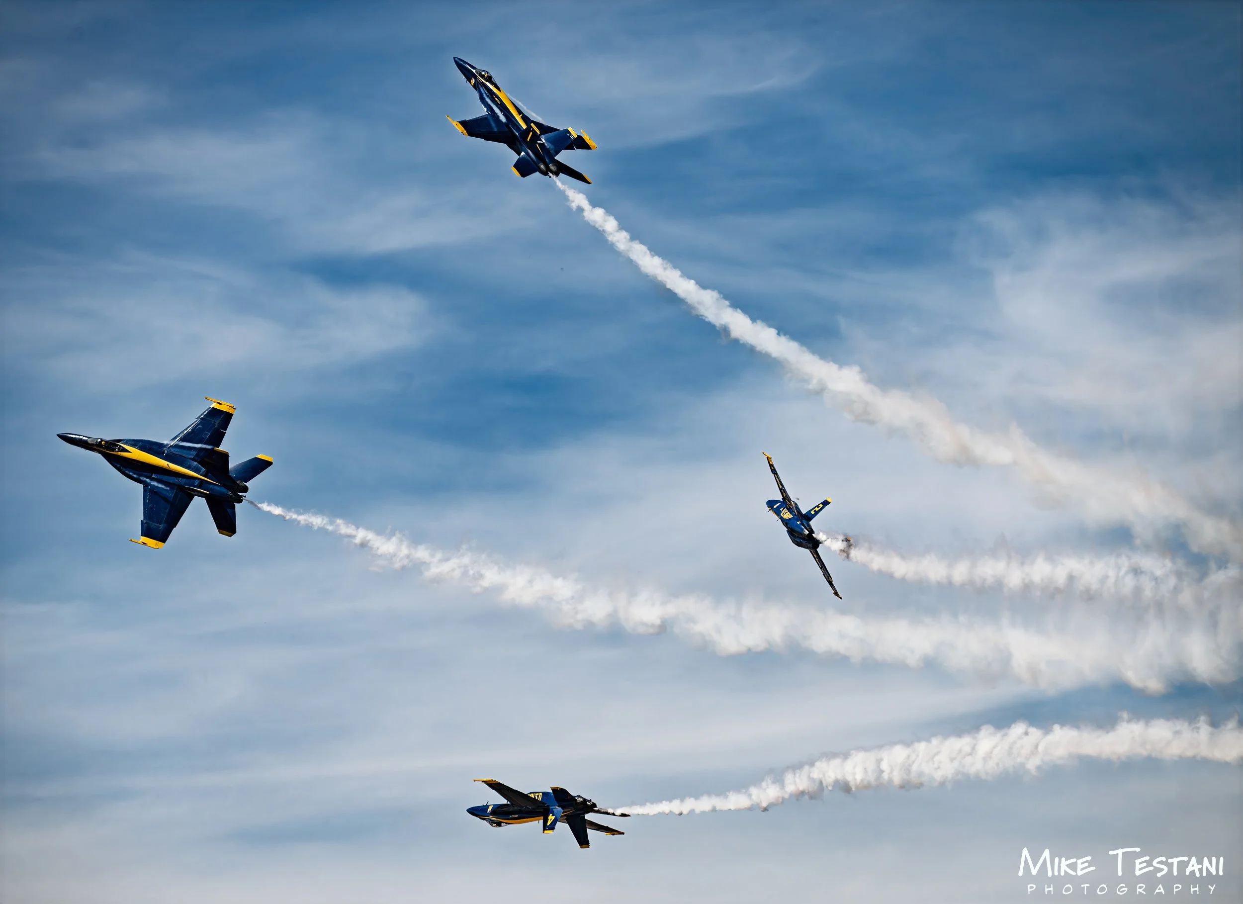 Fighter jets flying in a formation with smoke trails in a clear blue sky, part of an air show display.