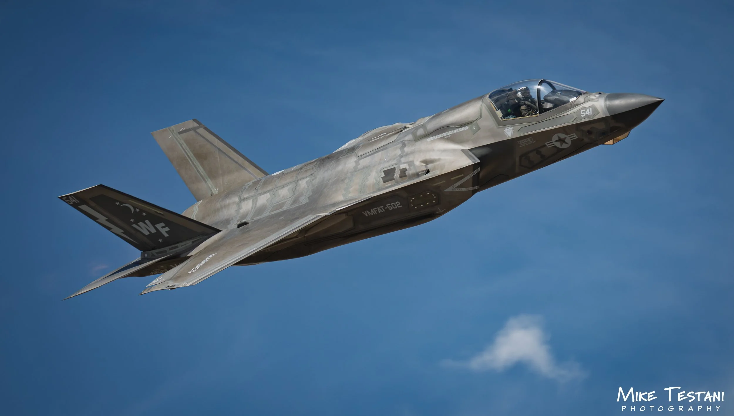 A fighter jet flying in the clear blue sky.