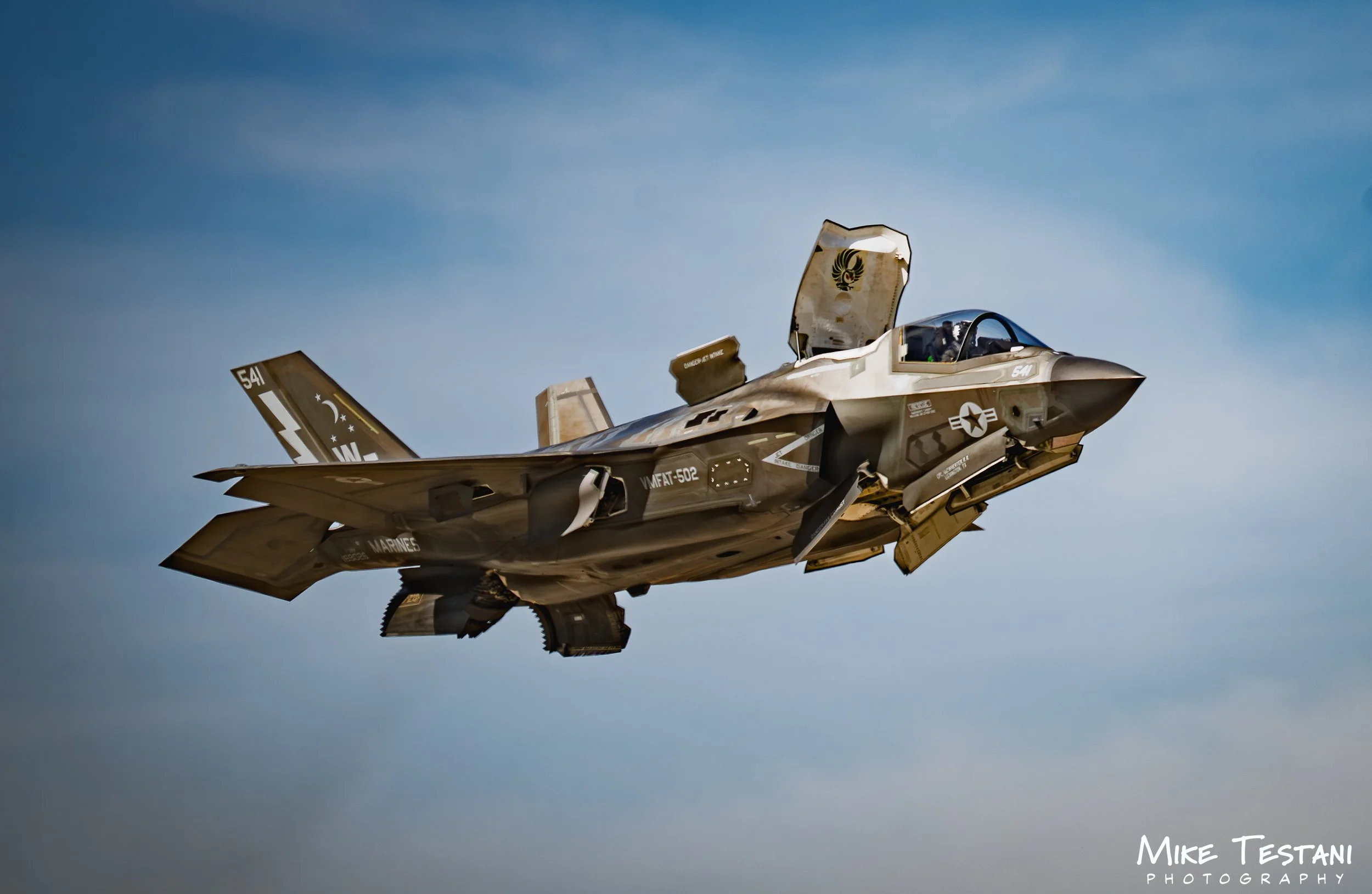 An F-35 fighter jet flying in a clear blue sky.