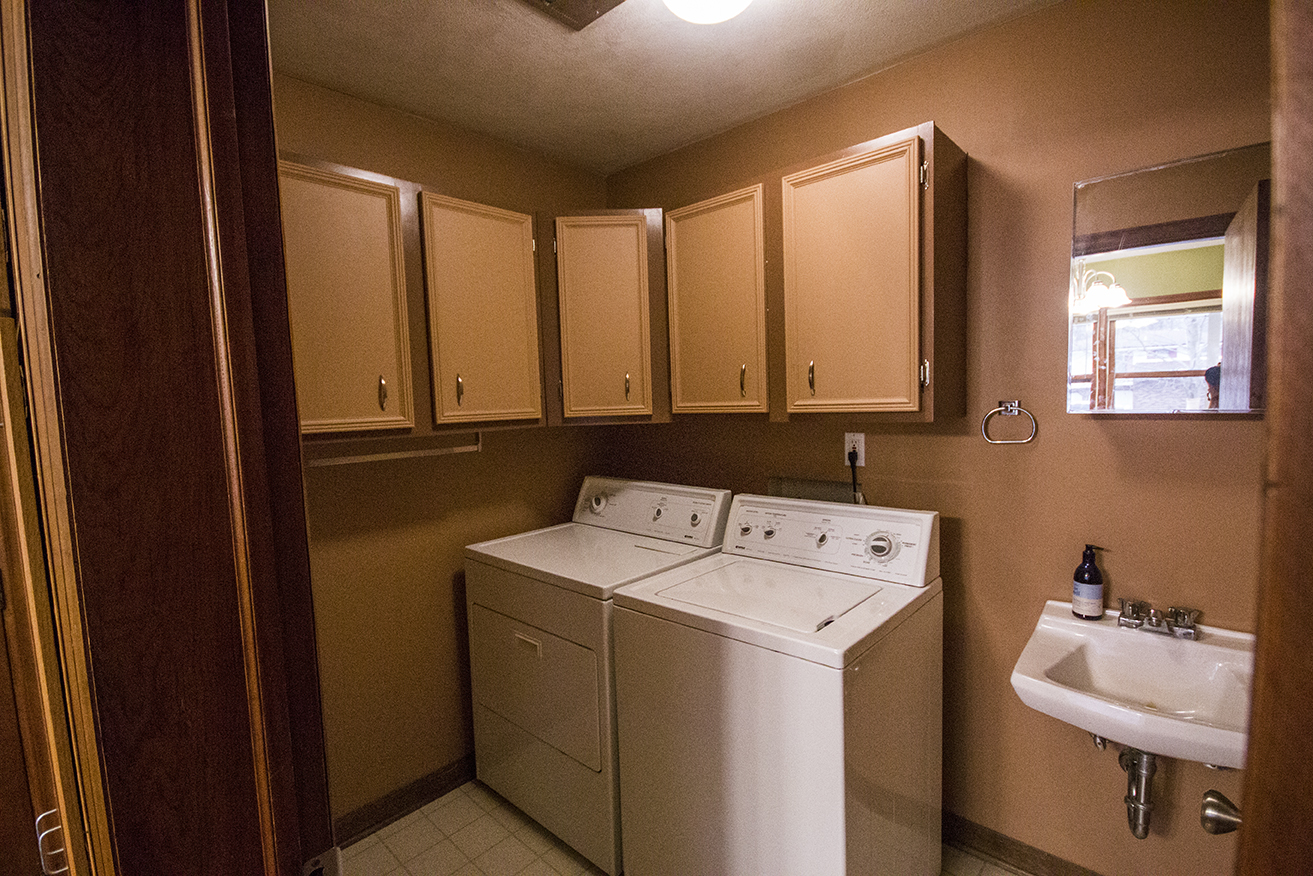 Changed: Brown paint for walls, dark brown paint for cabinets, brown paint for cabinet doors, new hinges and handles for cabinets, removal of sink hardware, washing machine and dryer, new light fixture.