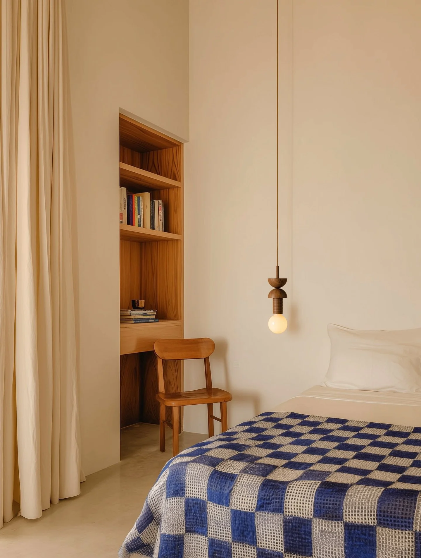 A room that holds space for stillness and texture, layered with natural materials, tonal wood, and a single Junit pendant in walnut. Its geometric form becomes a quiet gesture within the considered setting &mdash; a subtle counterpoint to the softnes