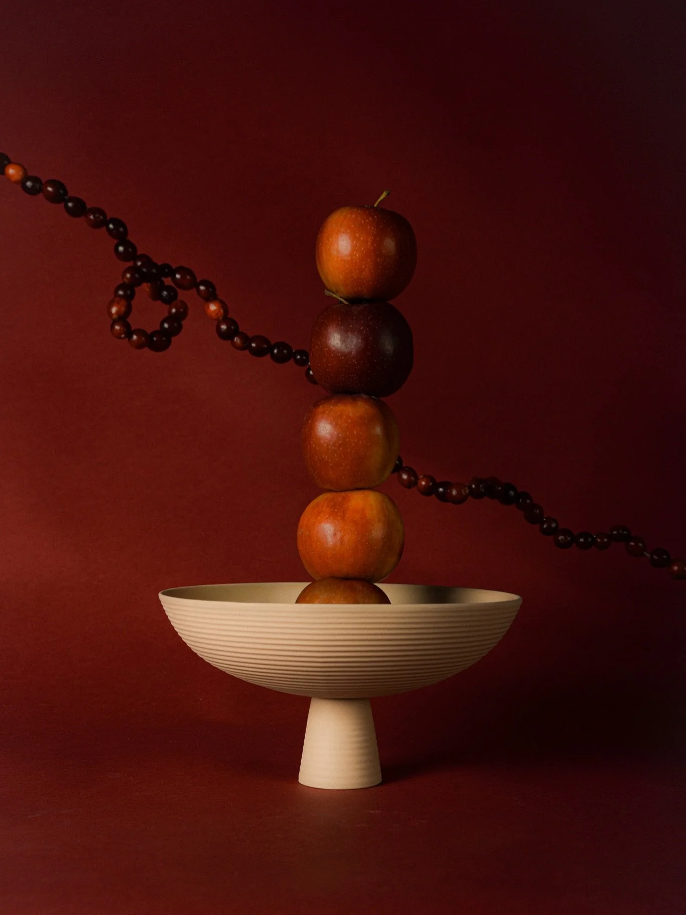 Hand-cast in our in-house ceramic workshop, the Dais Bowl carries the imprint of mindful making.
Set here amidst deep seasonal hues, it becomes both vessel and sculpture &mdash; a subtle nod to winter rituals, shared tables and the beauty of objects 