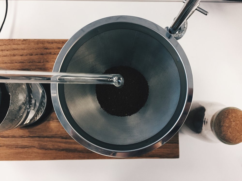 Heated water travels through glass tube and into coffee grounds