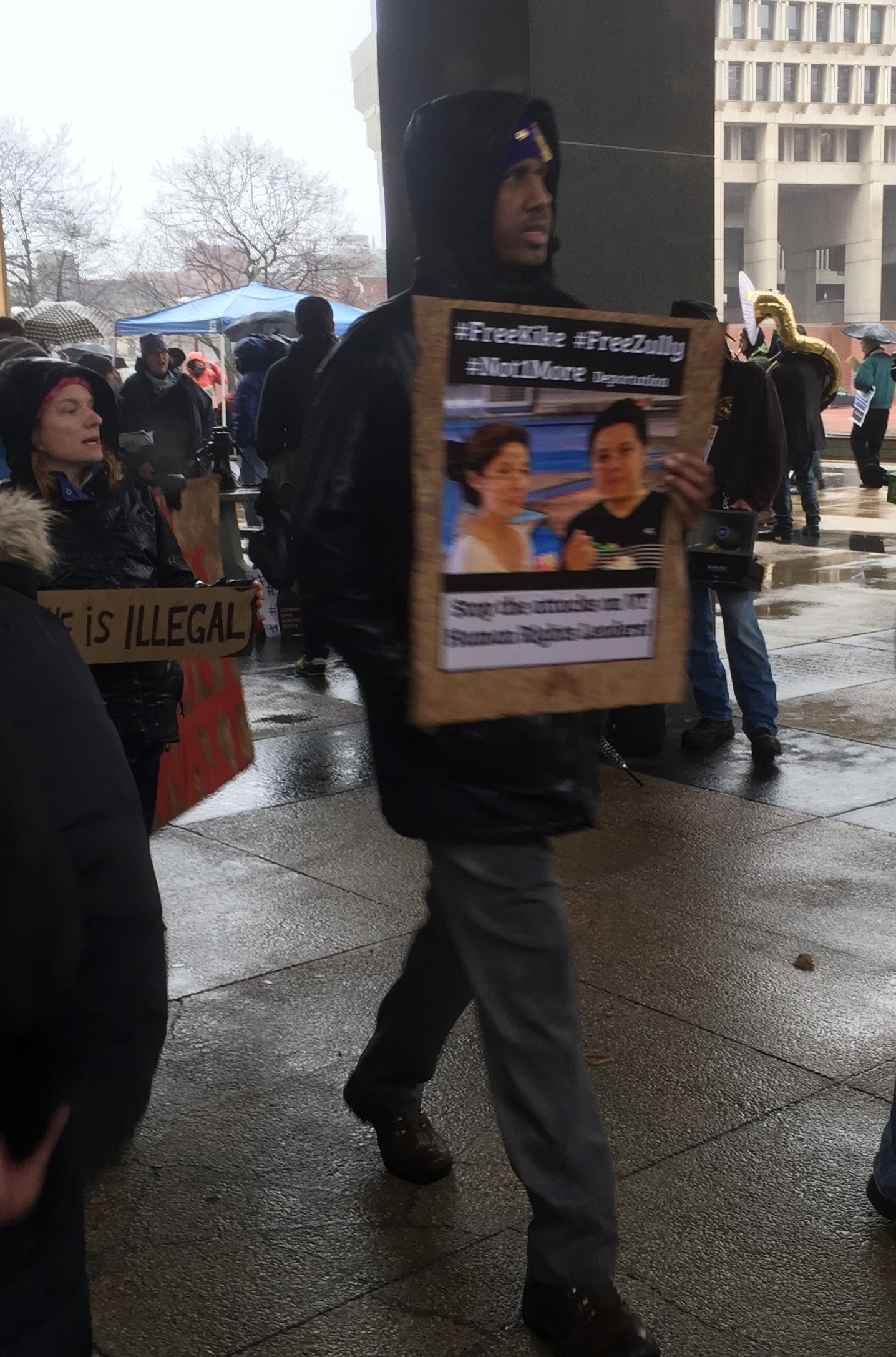 Protester walks with a #FreeKike #FreeZully sign at the Migrant Justice Rally