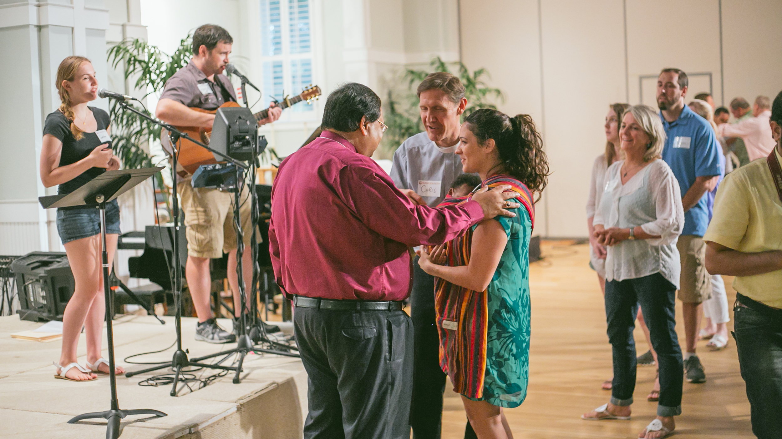 The Right Reverend Probal Dutta prays over and blesses Holy Cross member Jordan Tate and her son Shepherd.