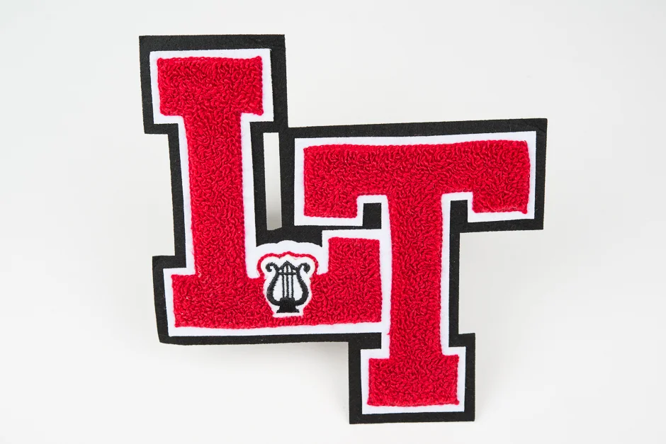 Two-color monogram with two-color contrasting felt border and emblem