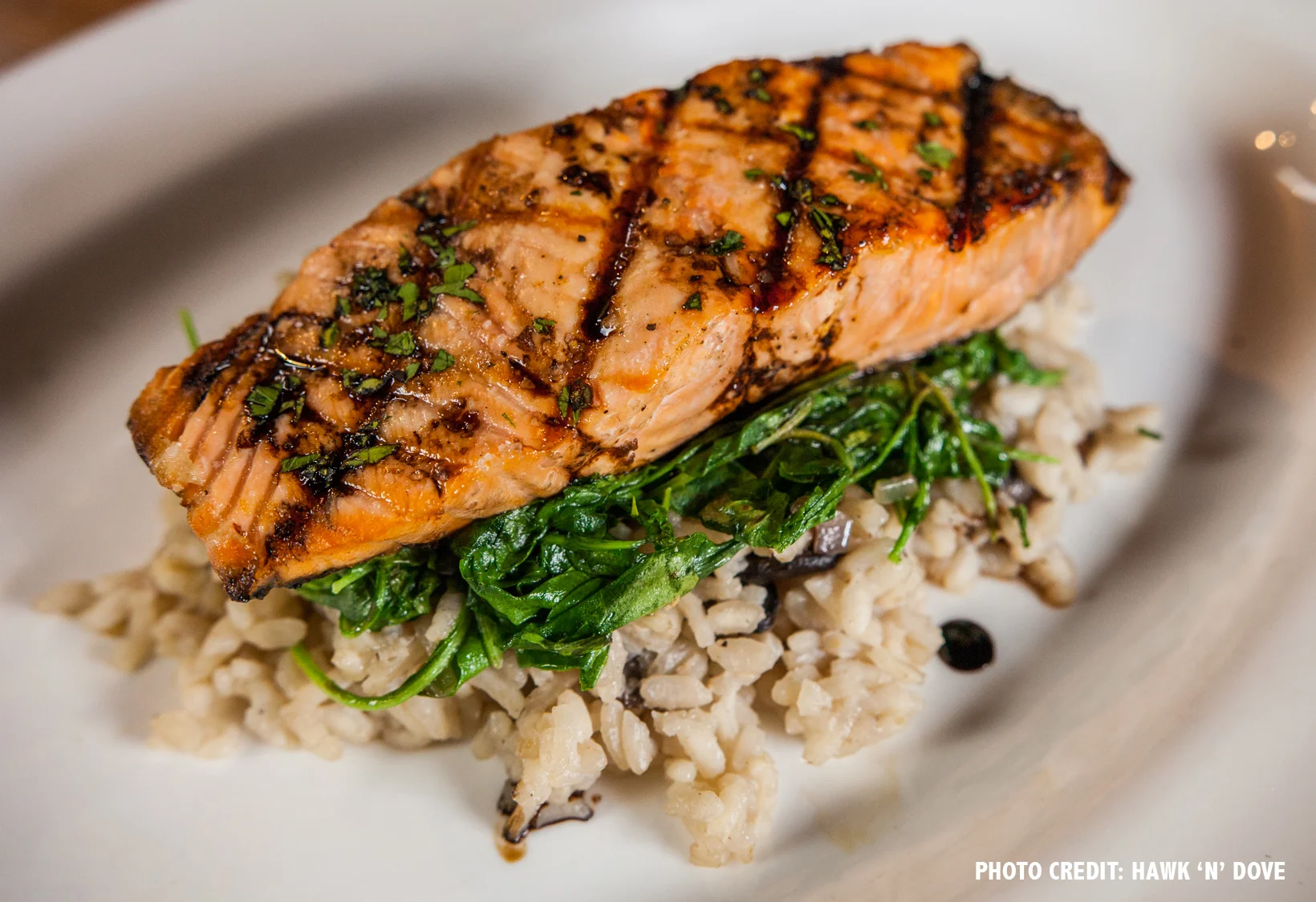 Grilled Atlantic salmon with mushroom risotto, wilted arugula and balsamic glaze.