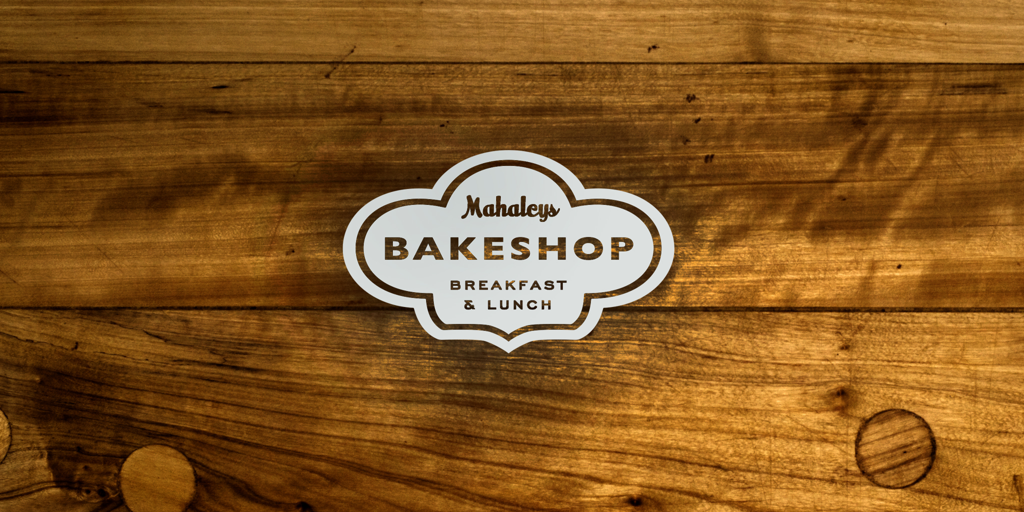 IDENTITY Mahaley's Bakeshop A small town appeal bakeshop needed a logo that sensibly revealed a warm and fuzzy emotion while conveying bakery. The puffy icon shape denoted both baked goods rising as well as a baker's hat.