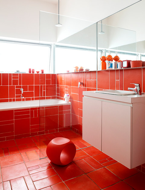 Dinosaur Designs homeware accessories and Japanese collectables dress the family’s orange bathroom.