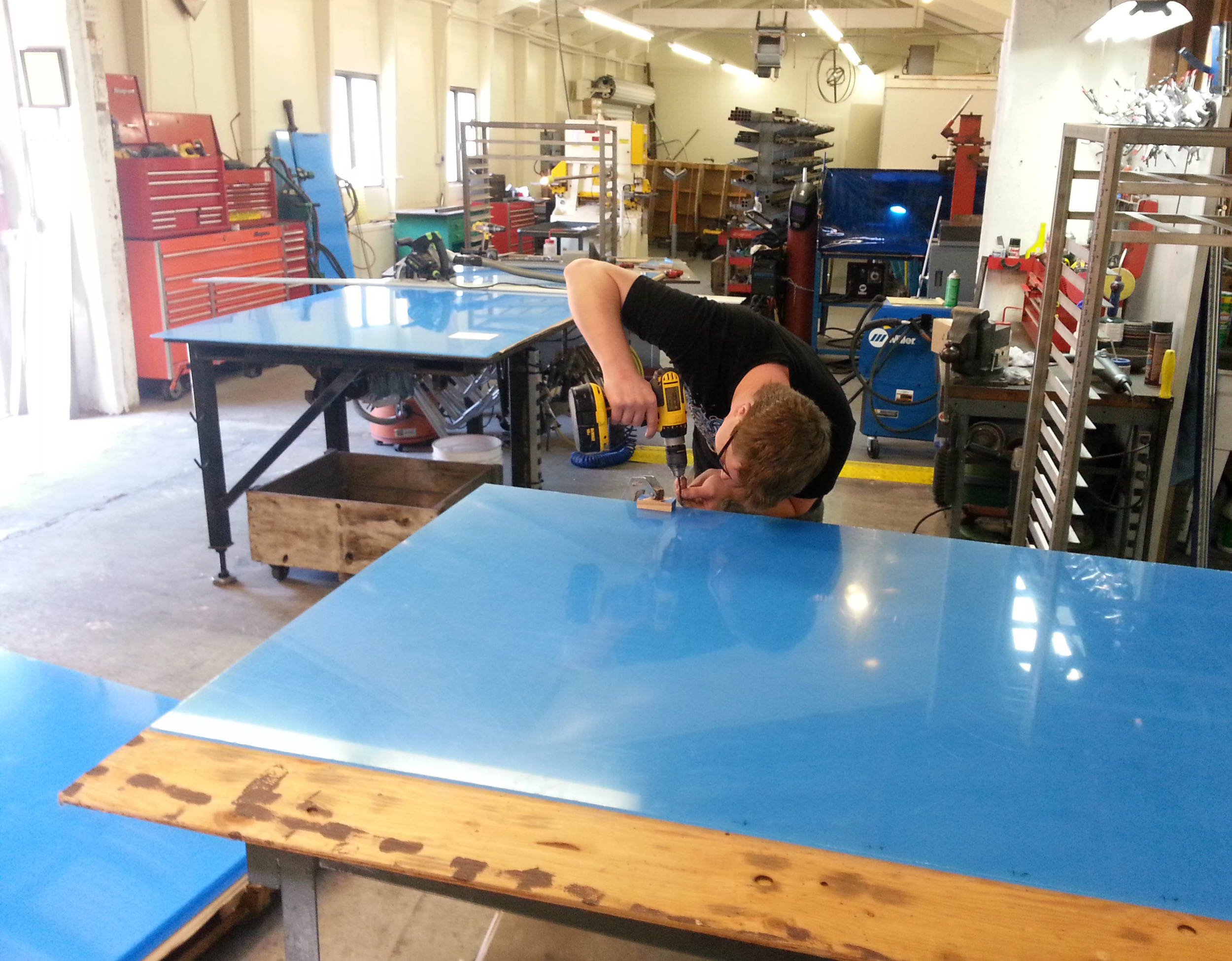 Matt lining up to drill one of the many, many holes required in the Plexiglas sheathing for the three cabinets.