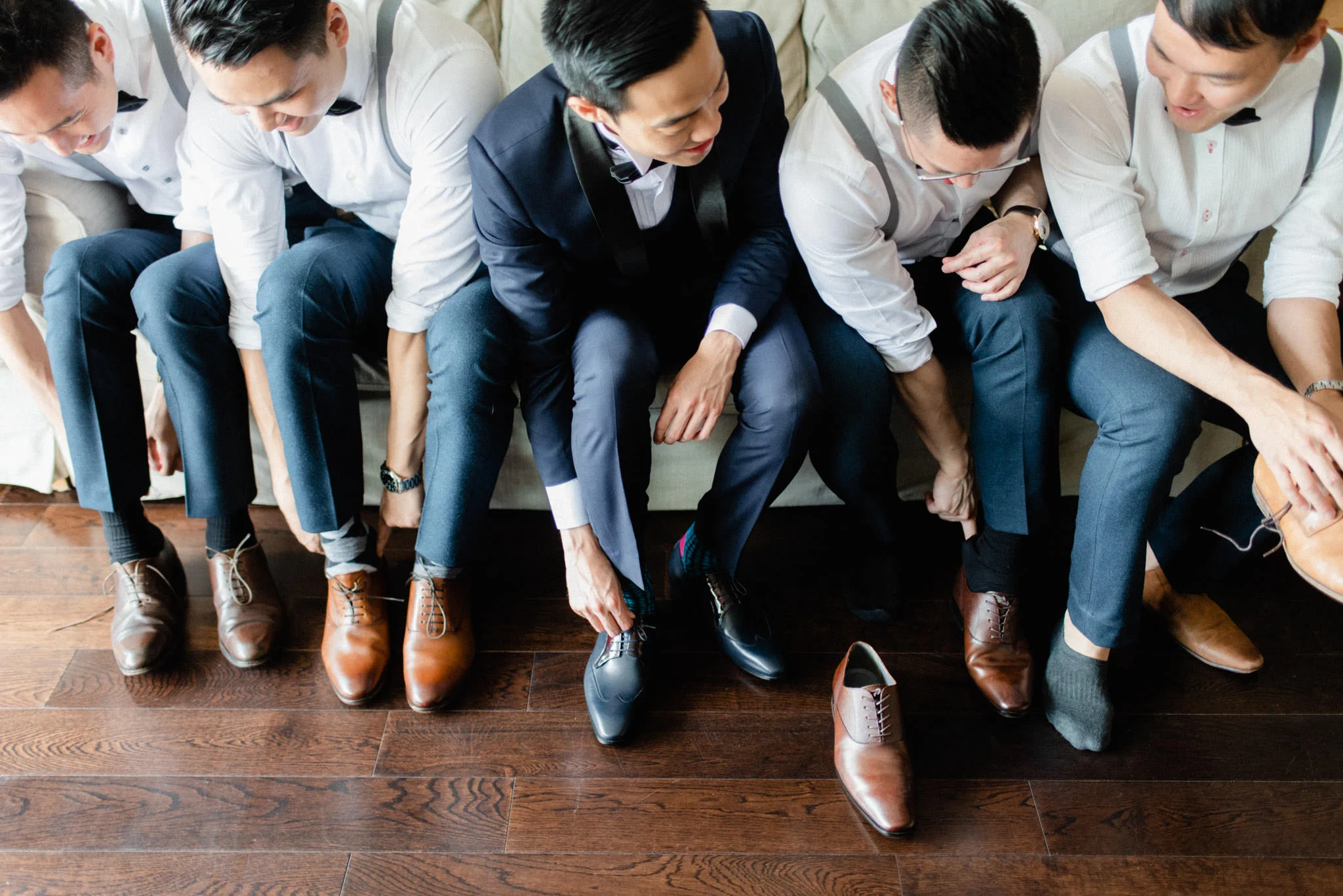 Groom and groomsmen putting on shoes