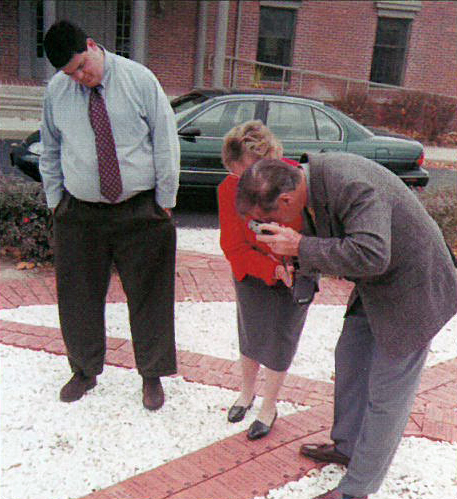 While photographing his brick, and the adjacent bricks in the Pathway of Brotherhood upon which are engraved the names of his brother (Philip C. Chapman, Omega/Penn State '57) and father (George W. Chapman, Omega '32), Brother Chapman and his wife, Marion, are assist-ed by Scott Thomas (Delta Kappa/Ball State '97), Director of Chapter Services