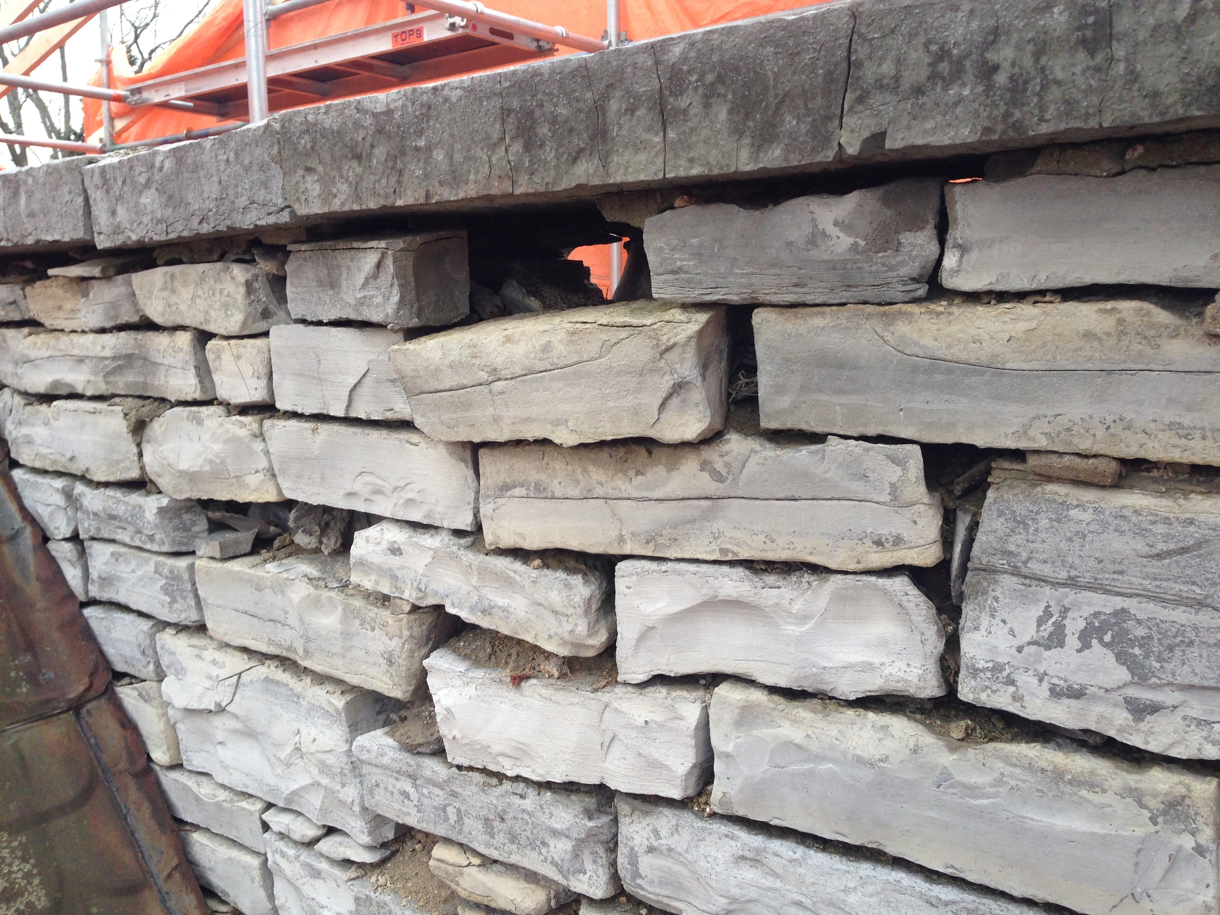  Dislodged stones, a result of moisture accumulation within the wall and resulting freeze-thaw movement.&nbsp; 