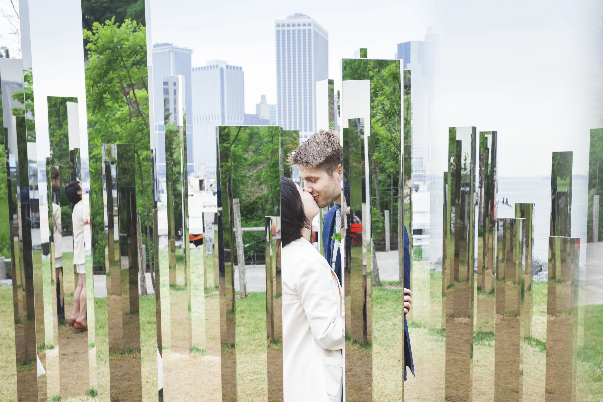 A very cool mirrored art piece along the river in NYC makes for a unique wedding couple shot.