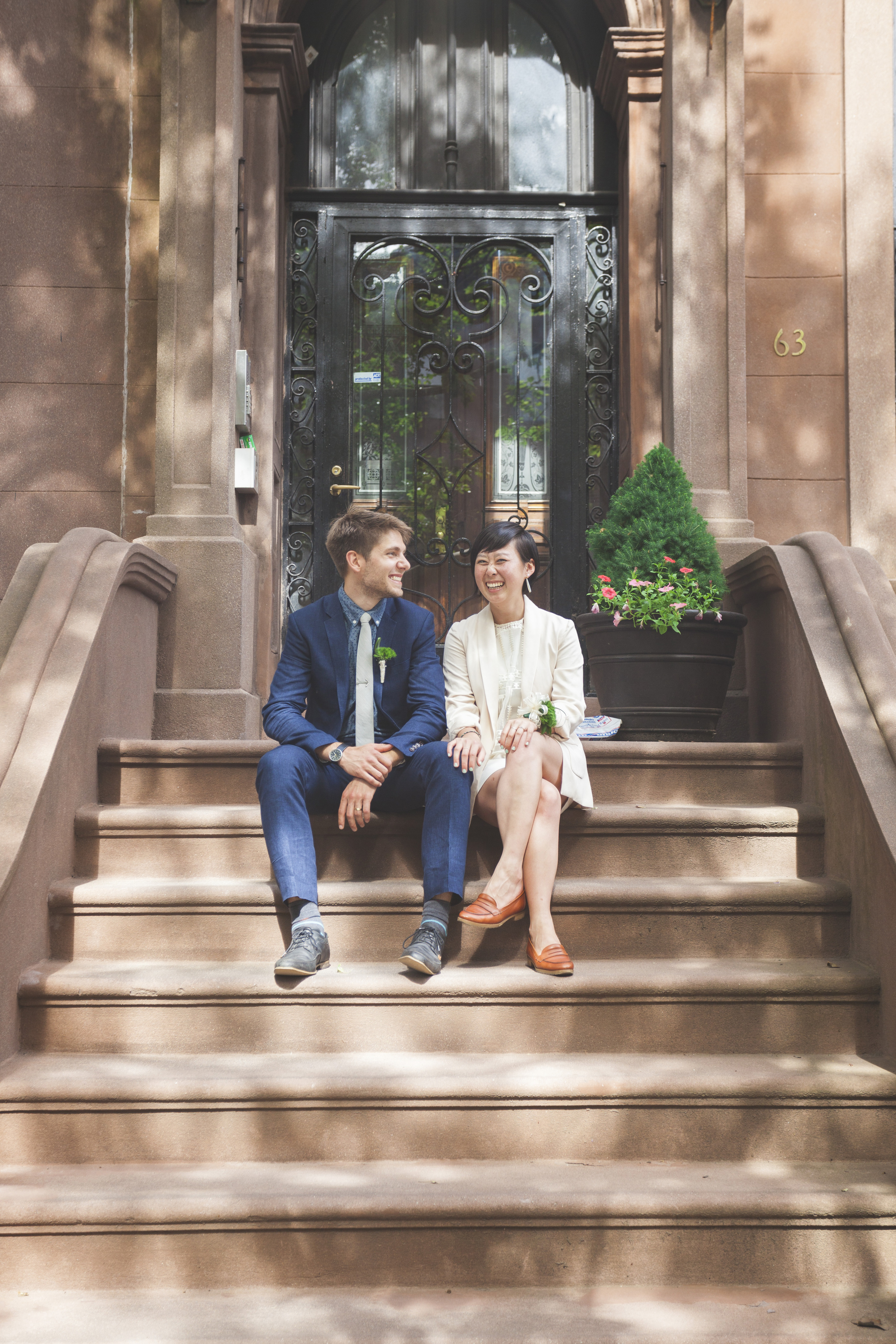 The happy couple outside a classic brownstone on their former street.