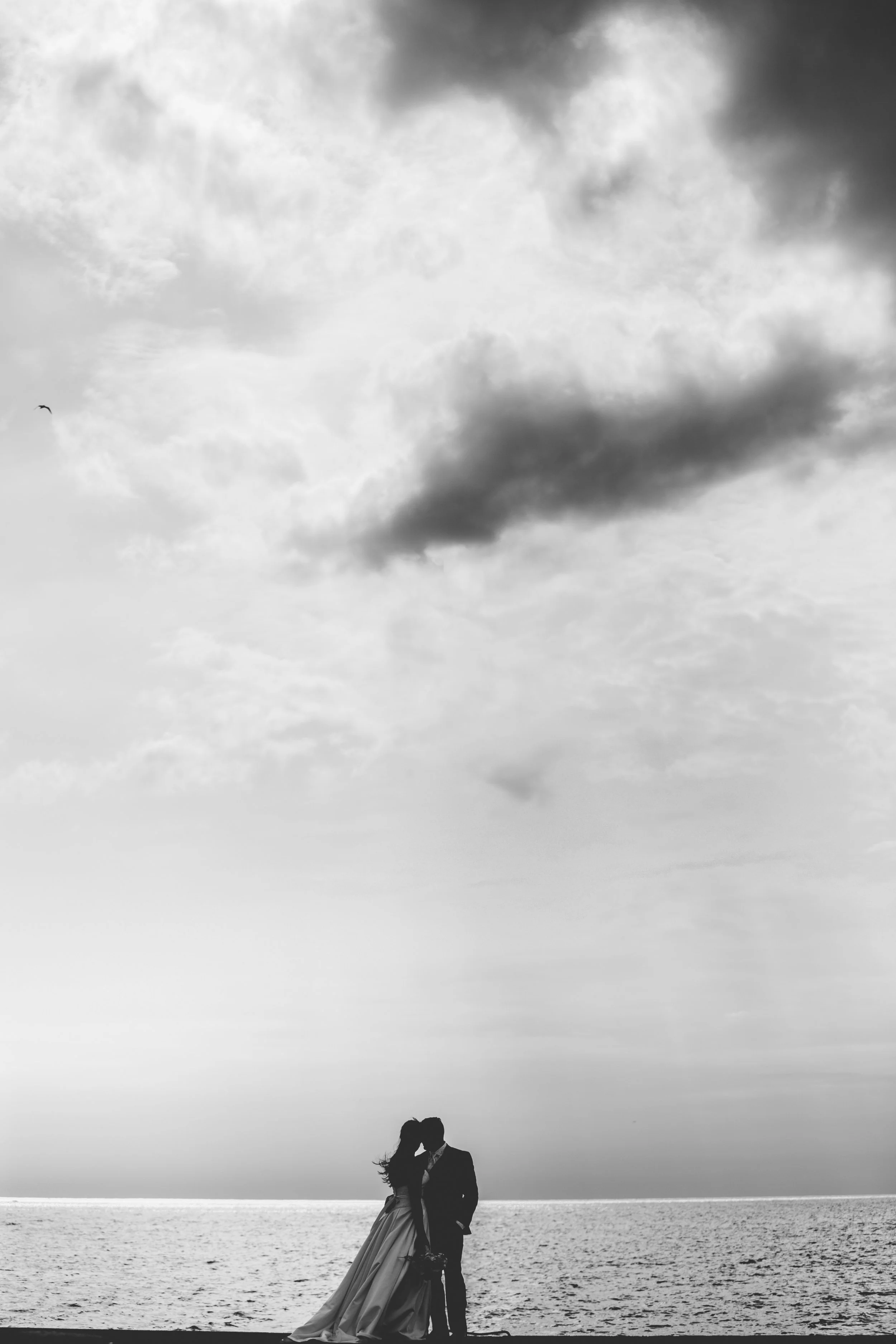 Couple silhouetted by Lake Huron at the end of a pier