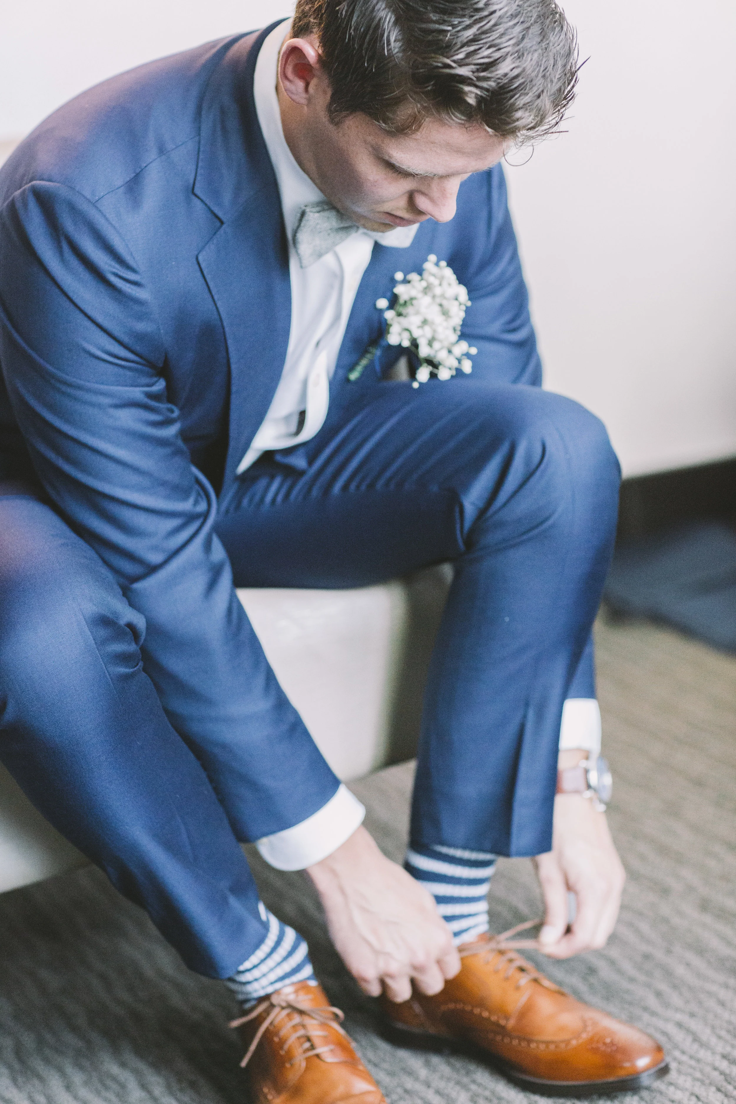 Groom lacing up dress shoes.