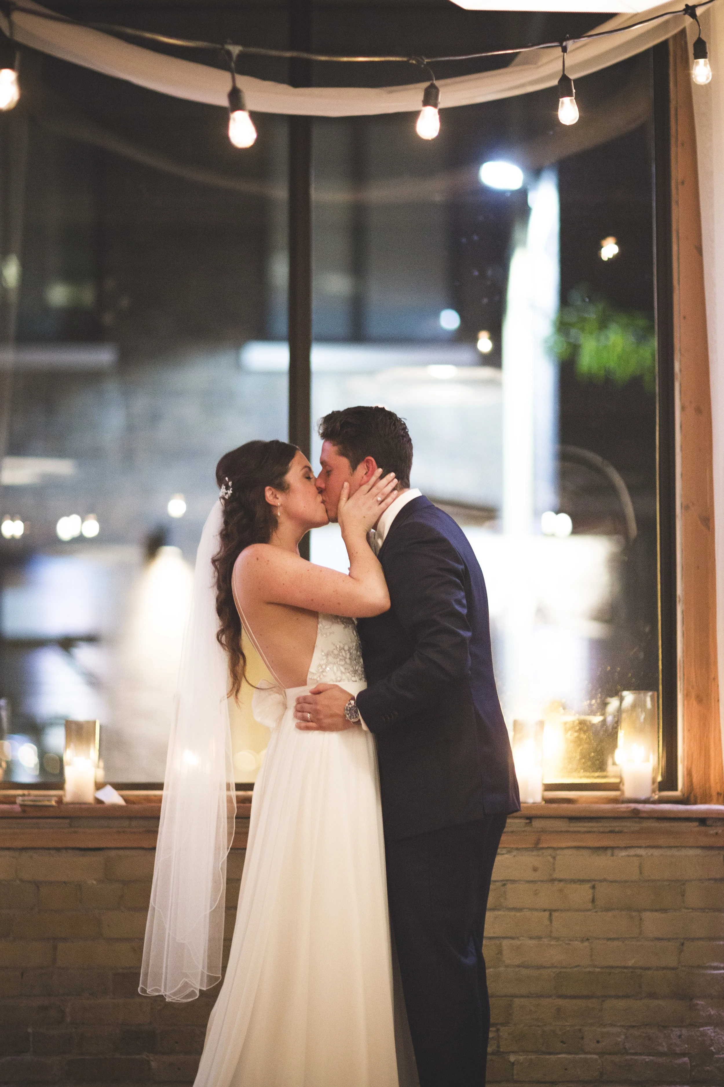Bride and groom kissing under the lights at 2nd Floor Events in Toronto.