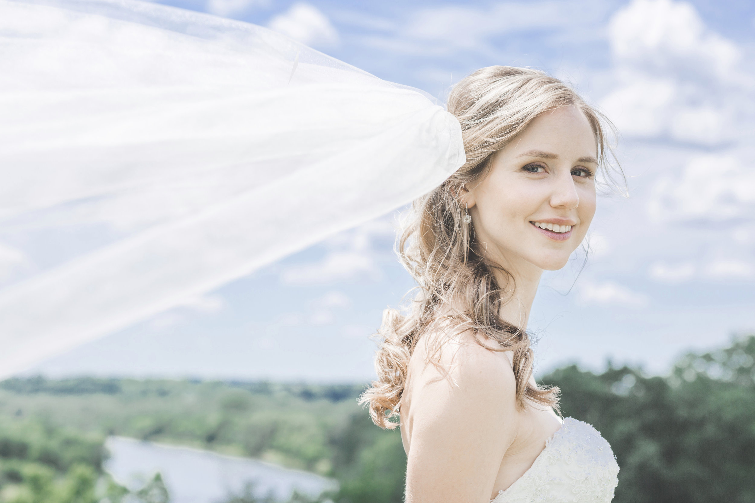 Bride with flowing veil photographed by the Grand River in Brantford Ontario.