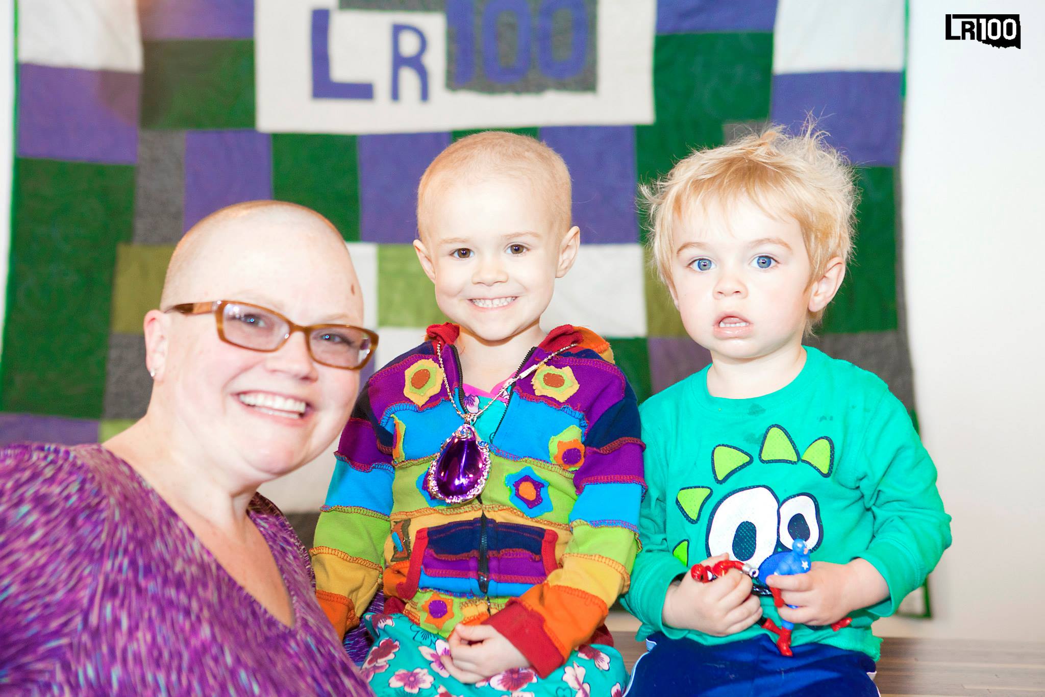 Andrea, Ainsley, and George with Andrea's LR100 quilt. Photo credit 241photography.com