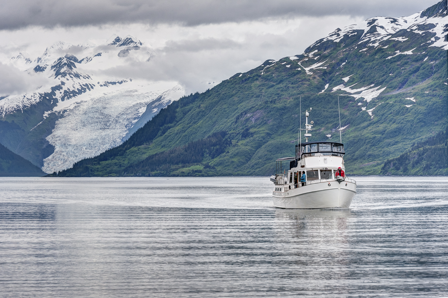 Kathy Cox on the bow of her boat, Telita , with the Coxe Glacier in the background. Only separated by one "e".